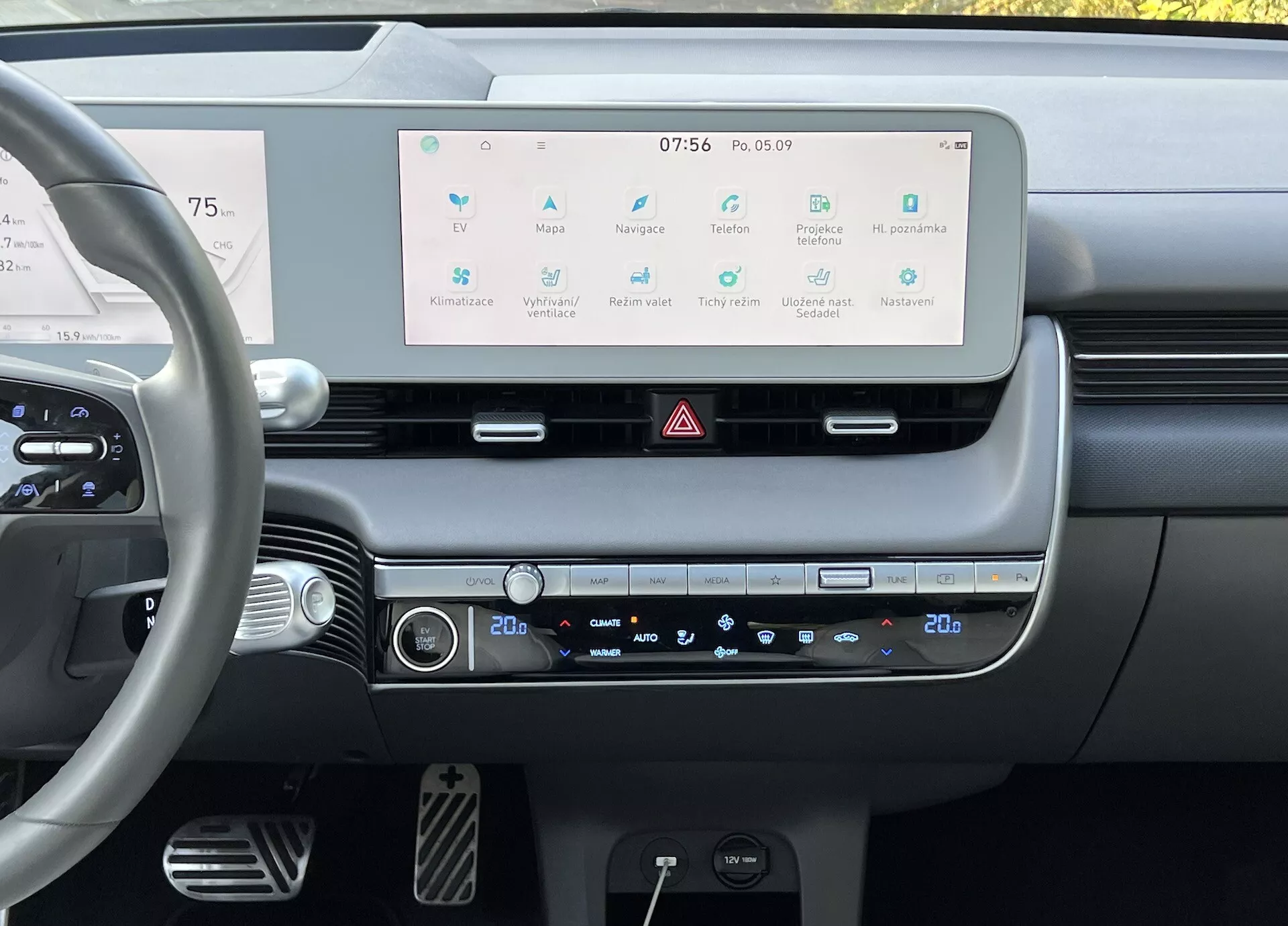 Interiör av Hyundai Ioniq 5 2021 som visar förarens perspektiv av instrumentbrädan med en stor infotainment pekskärm, dubbelzons klimatkontroll och moderna rattkontroller, betonar bilens avancerade teknologi och minimalistisk design.