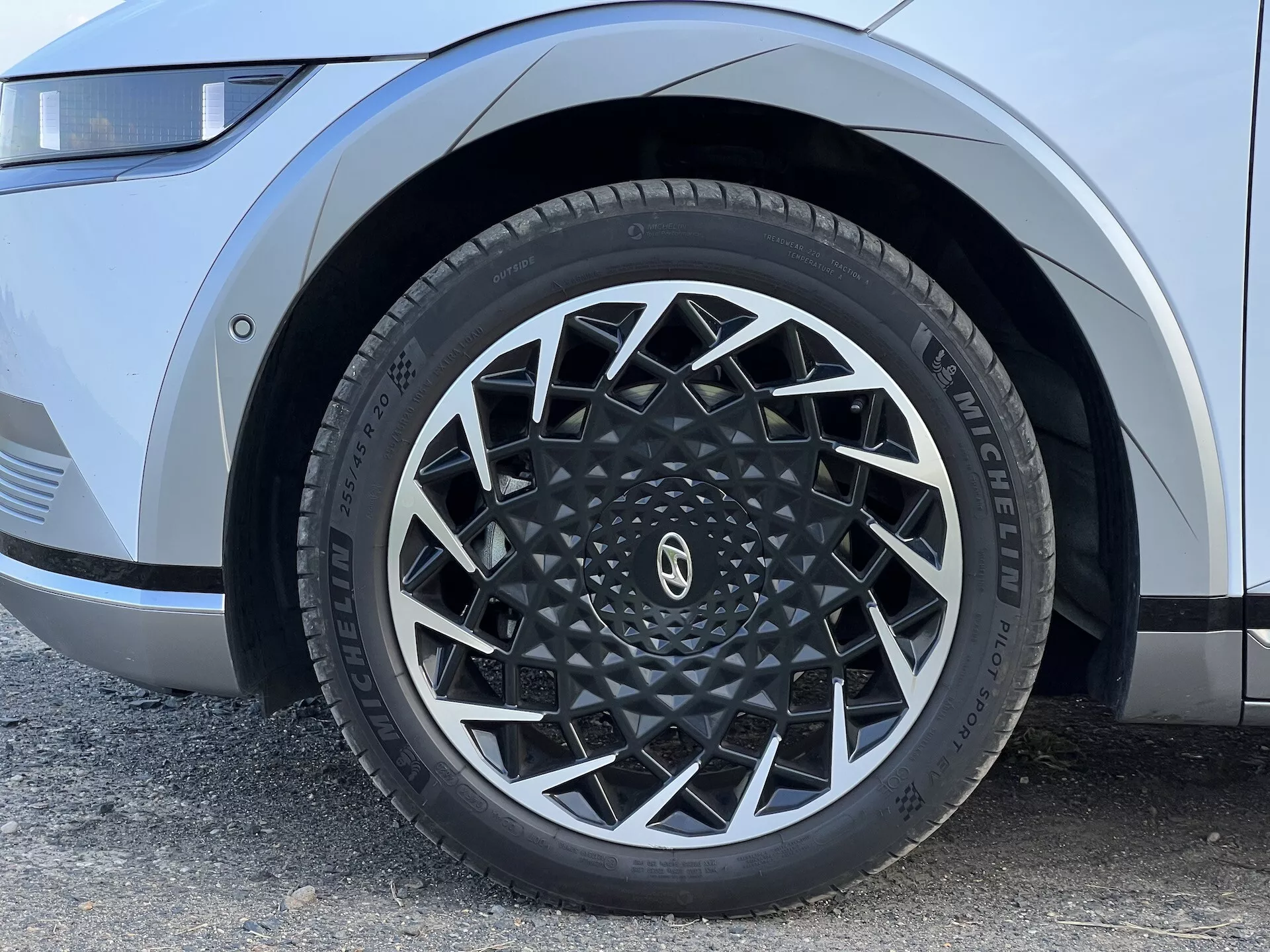 Närbild av Hyundai Ioniq 5 2021:s främre vänstra hjul med invecklad legeringsdesign och Michelin däck, framhäver moderna fordonsestetik och prestandaegenskaper