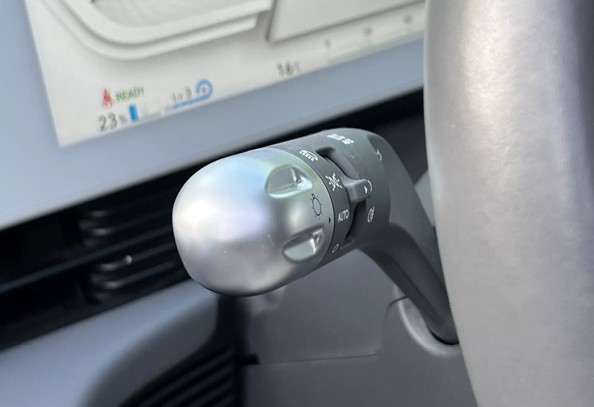 Närbild av Hyundai Ioniq-5 2021s blinkers- och ljusreglage på styrkolumnen, som visar symboler för strålkastare, autoläge, blinkers och ergonomisk design ur förarens perspektiv