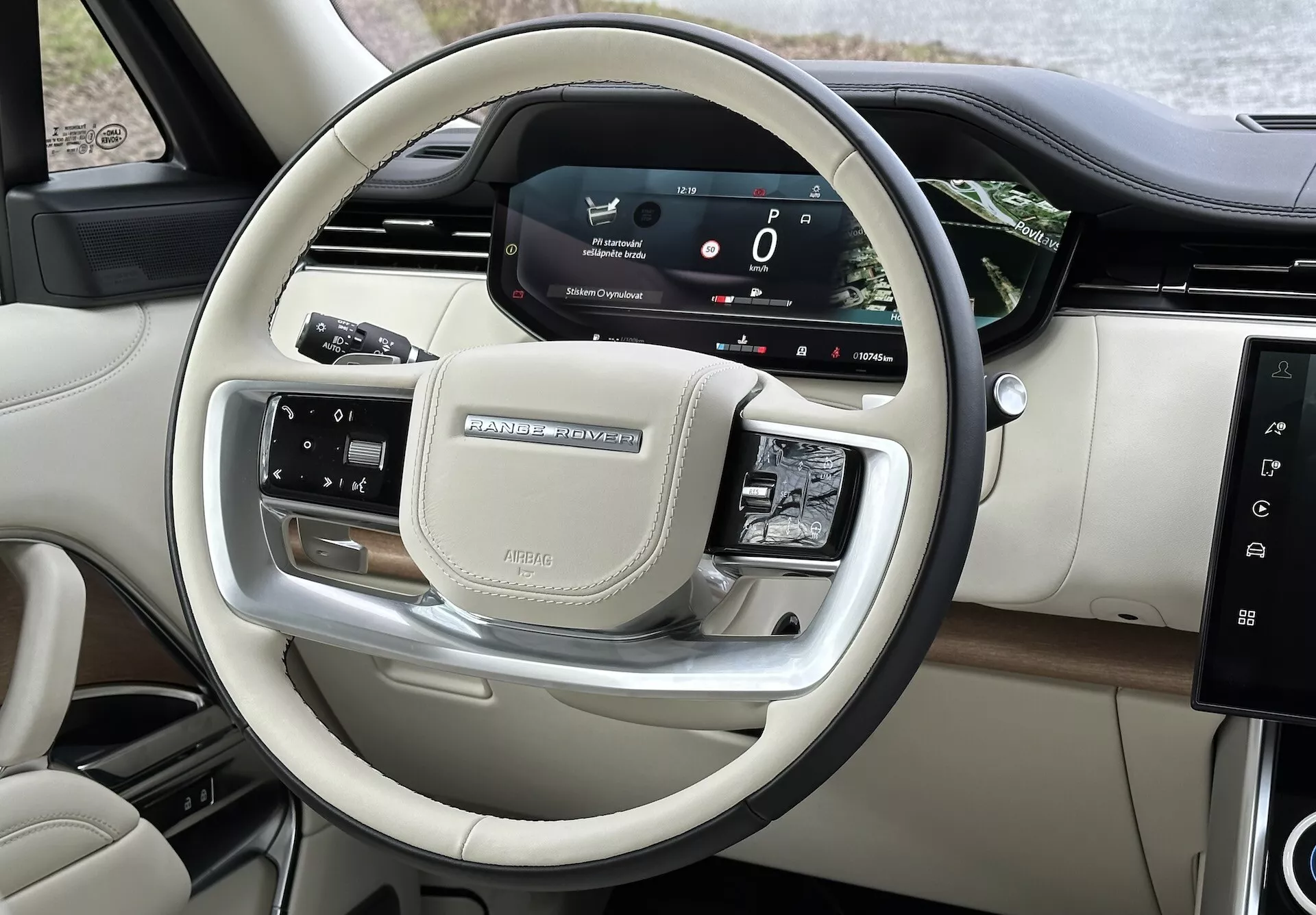 Interiörvy av Land Rover Range Rover 2021 som visar styrhjulets kontroller och förarens digitala instrumentbräda med kromdetaljer och lyxiga finishar