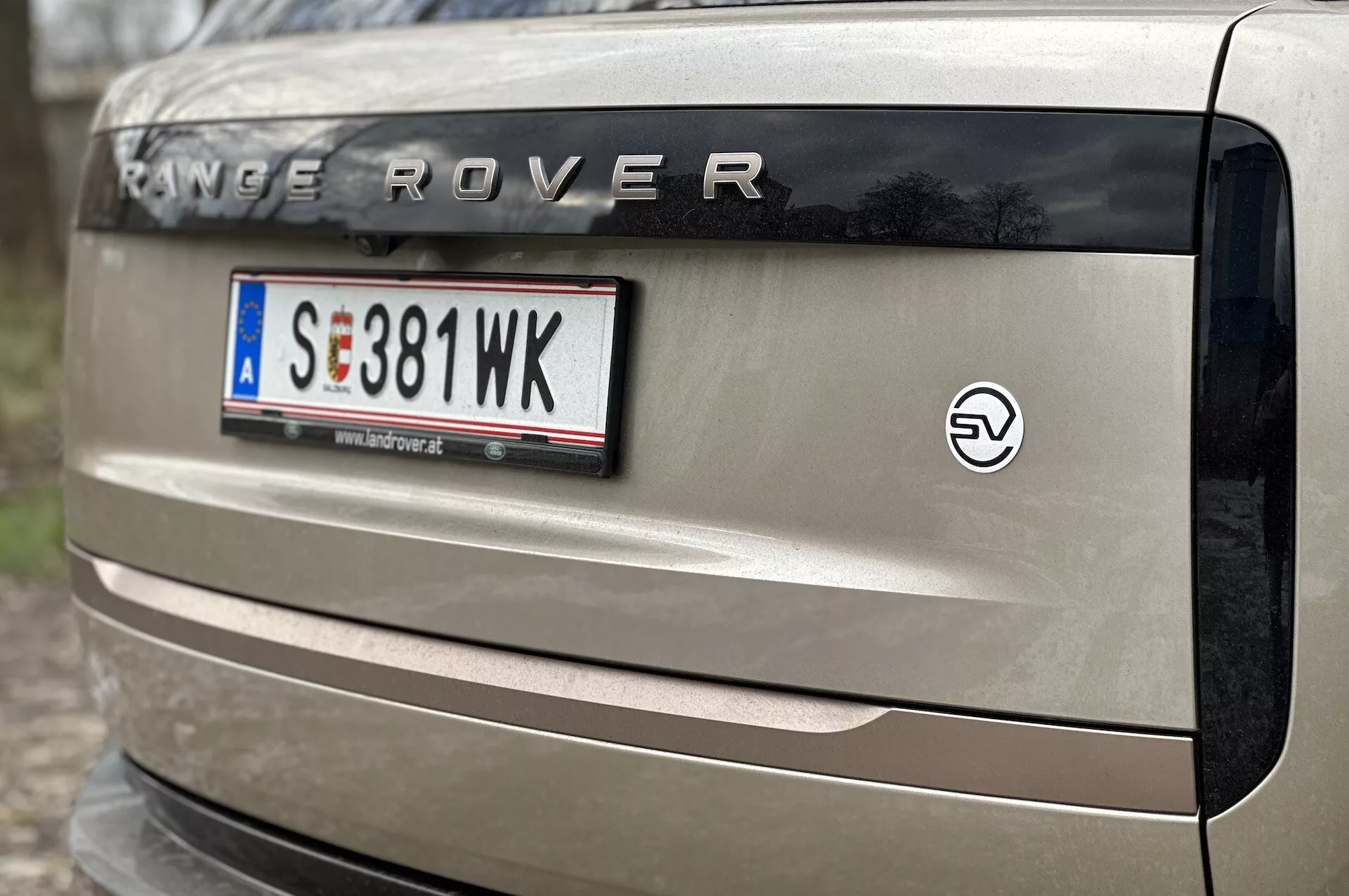 Närbild på en 2021 års Range Rovers baklucka med 'RANGE ROVER'-märkningen, europeisk stil på registreringsskylt, EV-emblem och en del av bakljuset