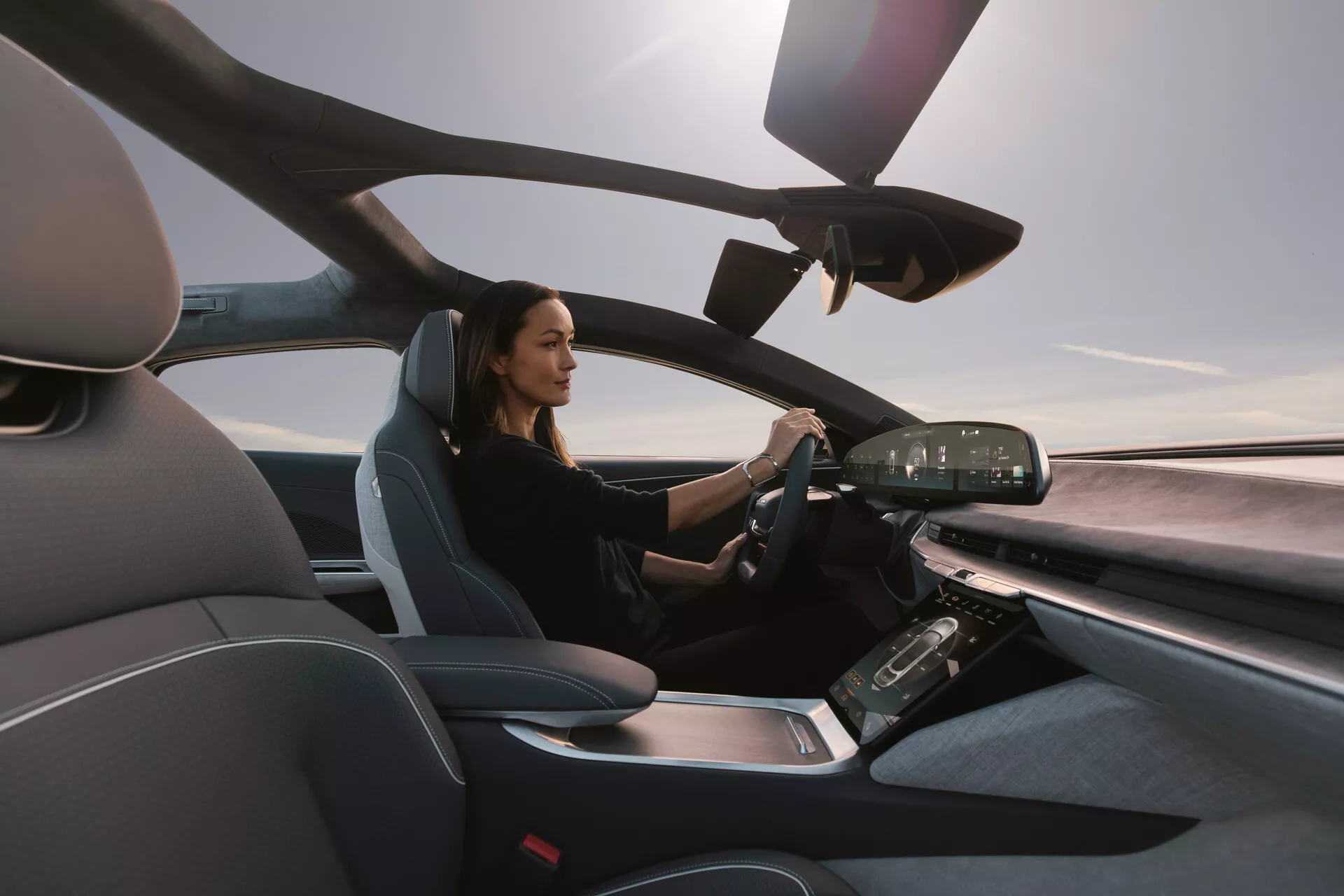 Interiörvy av Lucid Air 2022 från passagerarsidan, som visar det moderna förarsätet och avancerade instrumentbrädan med digitala skärmar och pekskärmskontroller, vilket lyfter fram en lyxig och teknologiskt avancerad design