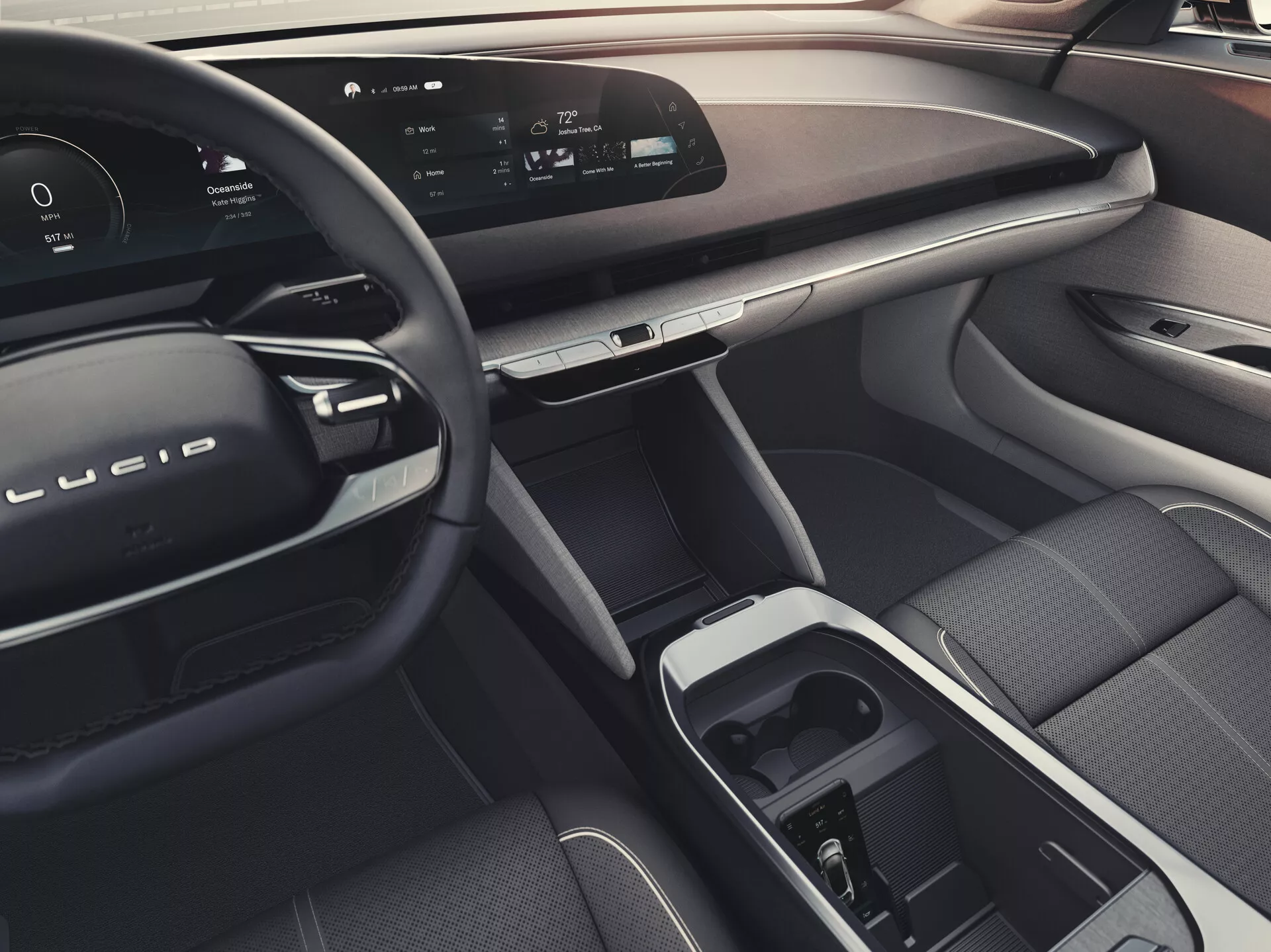 Interiörvy av Lucid Air 2022 (1:a generationen) från baksätet, som visar en elegant instrumentpanel med kontinuerlig digital display, modern ratt med inbyggda kontroller, lyxiga material, central pekskärm och växelväljare i mittkonsolen, ergonomiskt framsäte för passagerare, avancerade fönster- och spegelkontroller på passagerardörren, och en övergripande atmosfär som tyder på omgivande belysningsfunktioner.