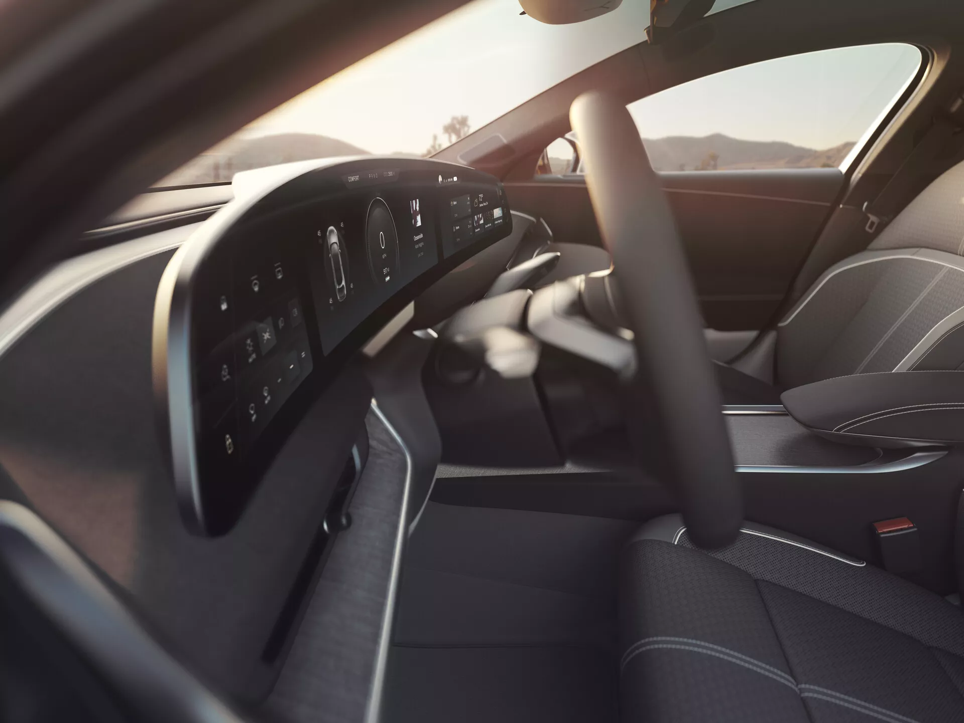 Interiör av 2022 Lucid Air första generationen sett från passagerarsidan, med en modern multifunktionell ratt med kontrollknappar, en helt digital instrumentpanel, en del av den eleganta mittkonsolen, högkvalitativt konturerat förarsäte och förardörrpanel med kontroller för elhissar och speglar, allt belyst av mjukt naturligt ljus.