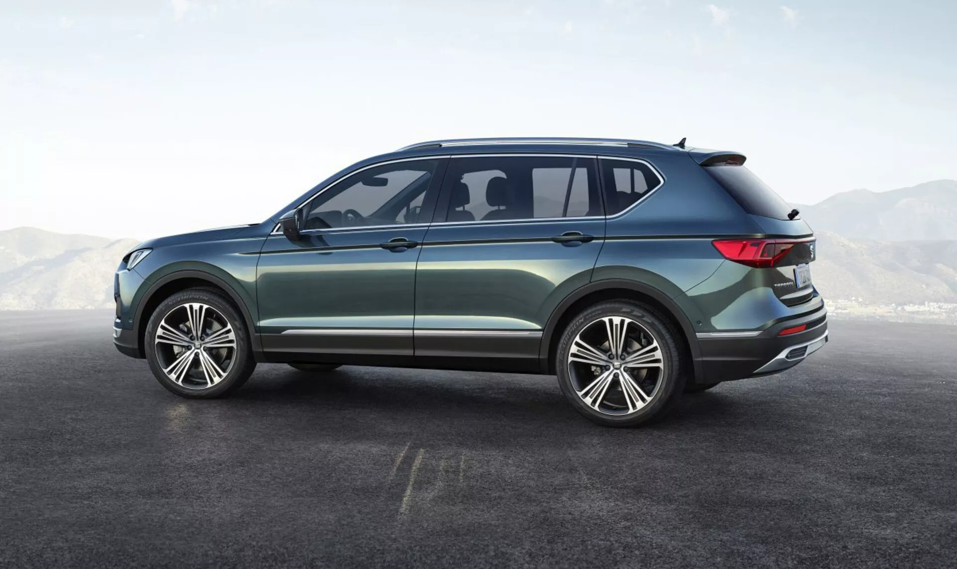 2019 års Seat Tarraco SUV visar upp sin sidobakre vinkel, med stora flerspakiga aluminiumshjul, fyrdörrarsdesign, eleganta sidorutor med ett litet aerodynamiskt bakre fönster, lätt sluttande bakre taklinje med integrerad spoiler, omslutande LED-bakljus, metallisk lack med krom yttre trim, framhäver dess moderna och mångsidiga design
