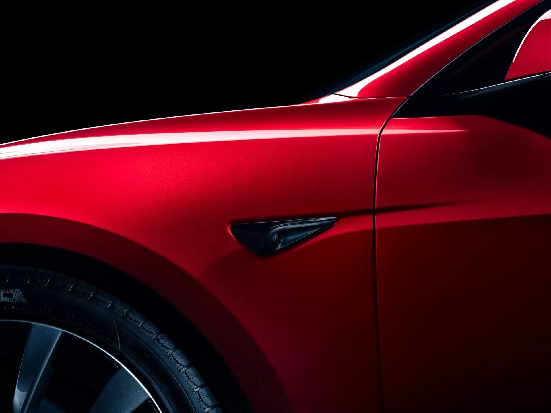 Facelift av Tesla Model-3 2023 i metallisk röd, visar elegant aerodynamisk design med fokus på skärmen, flerspakiga legeringshjul och sportiga lågprofildäck, framhävda av precisa panelgap och en distinkt sidomarkör.
