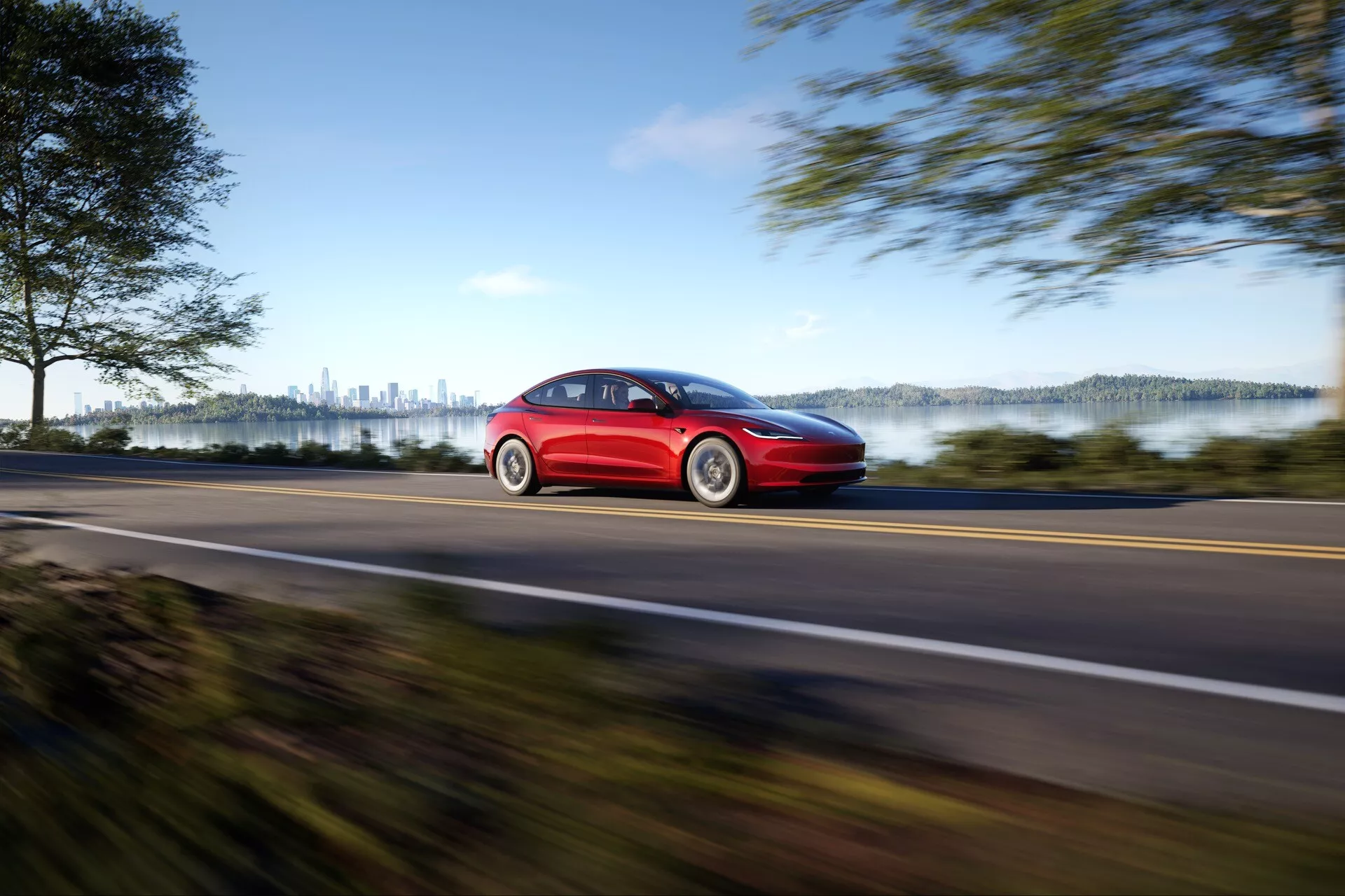 Röd Tesla Model 3 2023 (1:a generationen, ansiktslyft) som visar hastighet med suddighetseffekt på landsväg, sidoprofil