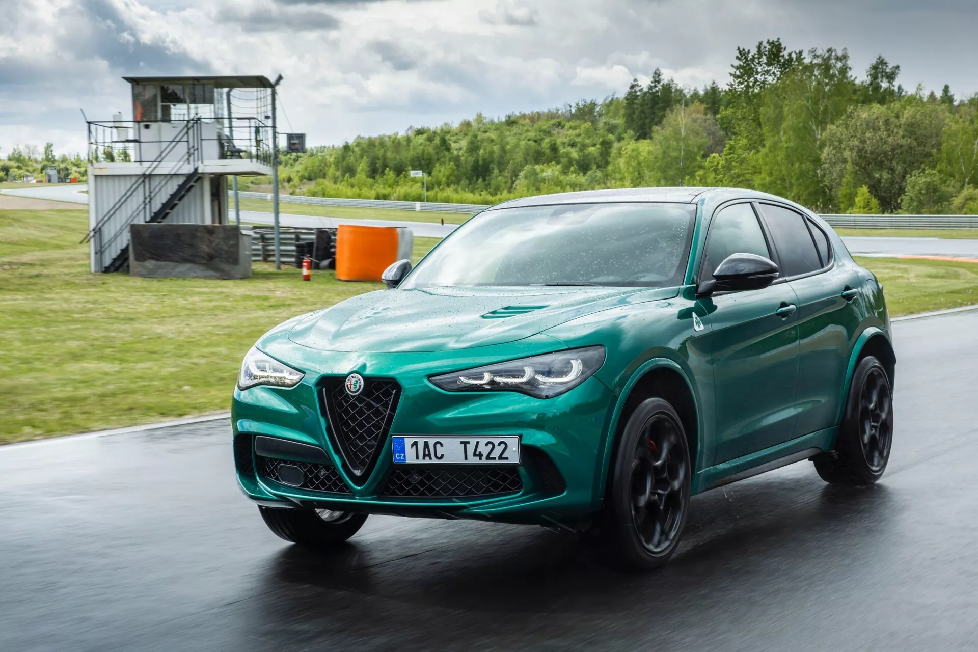 Alfa Romeo Giulia Quadrifoglio 2023 i metallisk röd färg som visar avancerad aerodynamik, snygg design med distinkt V-formad grill och bi-xenon strålkastare