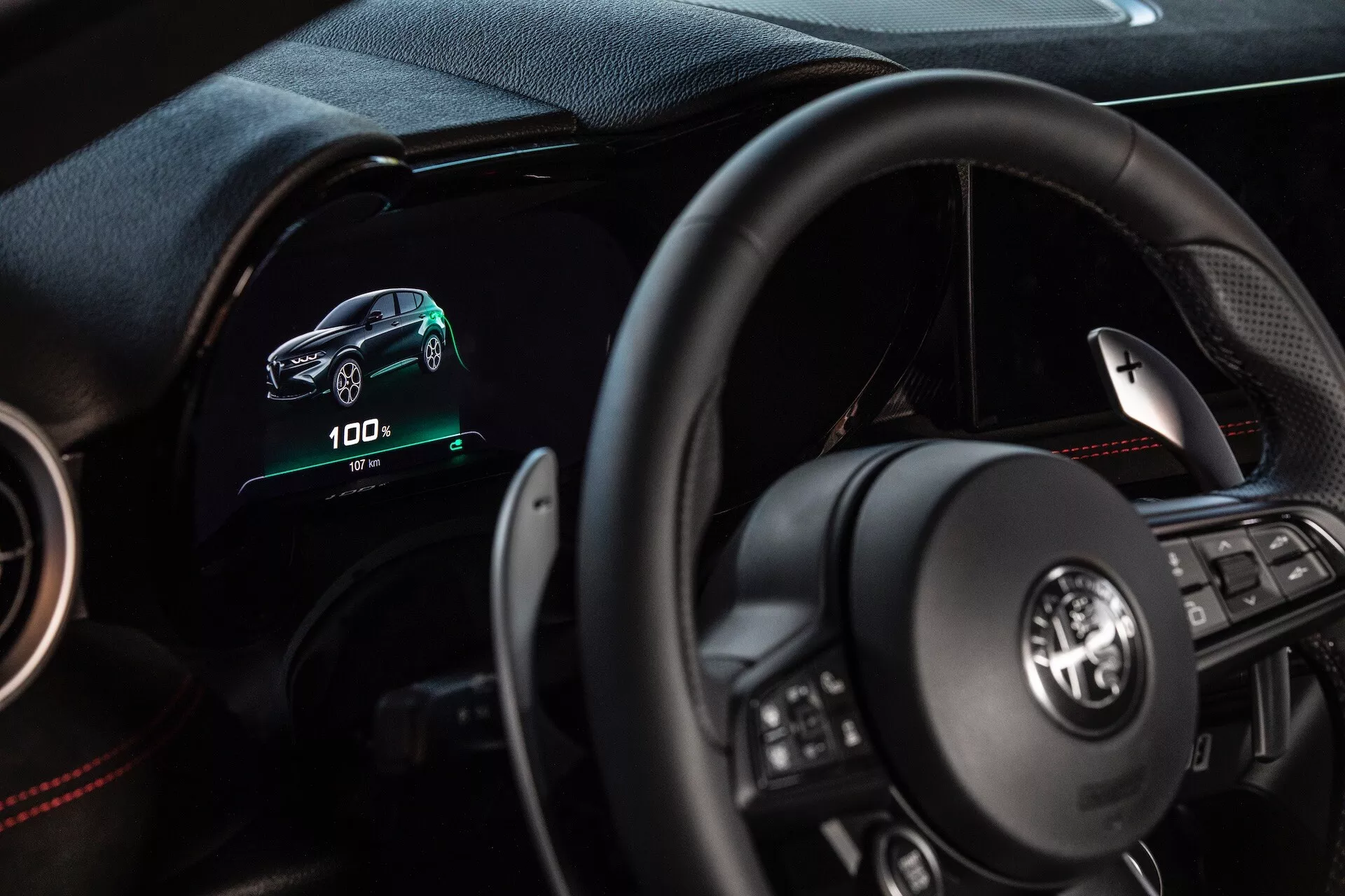 Interiör i Alfa Romeo Tonale 2022 som visar förarens perspektiv med digital instrumentbräda, multifunktionsratt och indikatorer för elfordon