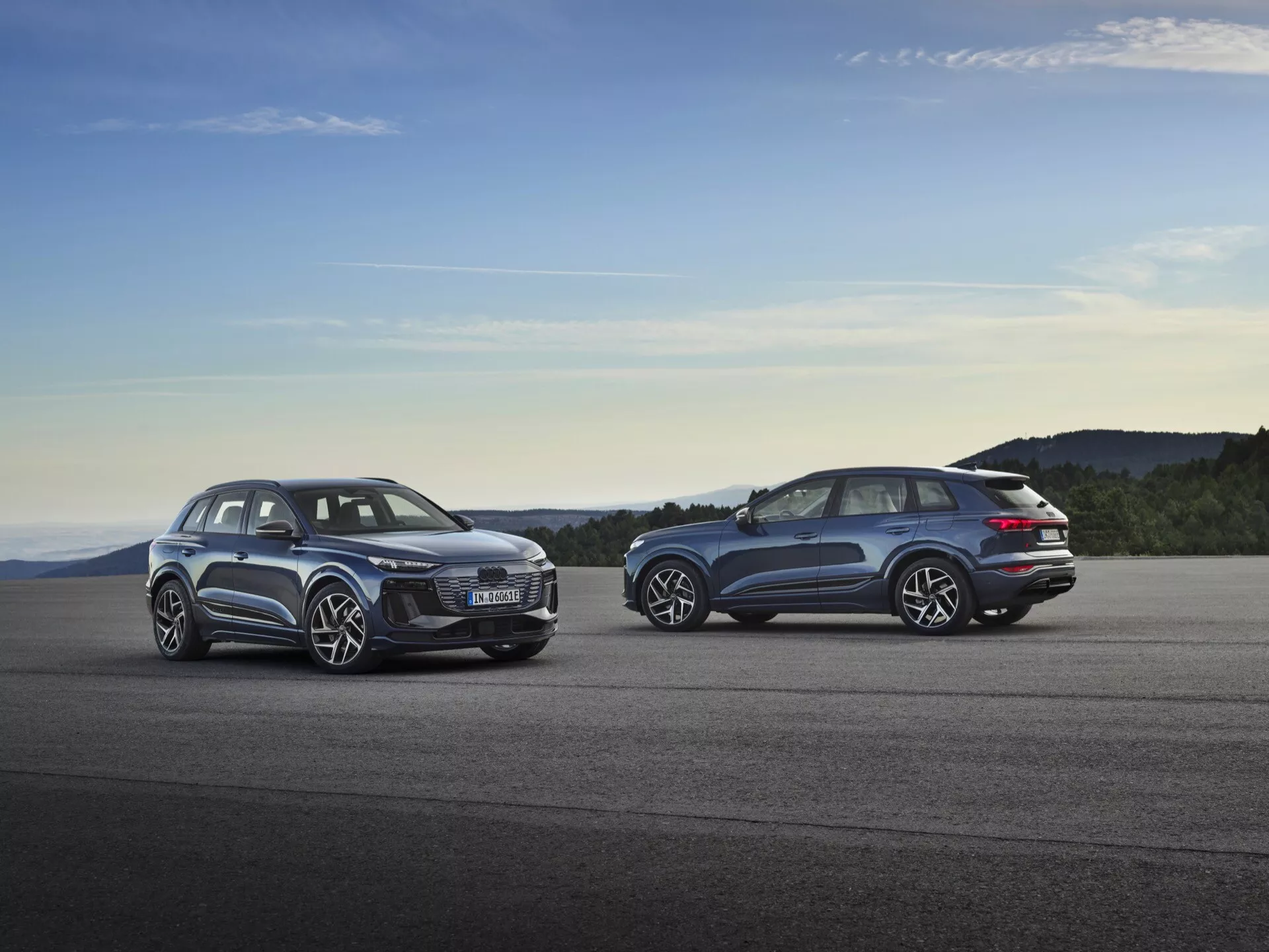 Audi Q6 e-tron 2024 (GF) parkerad vid solnedgången som visar upp sin eleganta aerodynamiska design, futuristiska LED-strålkastare, rymliga interiör, stora lättmetallfälgar och avancerad elektrisk drivlina.