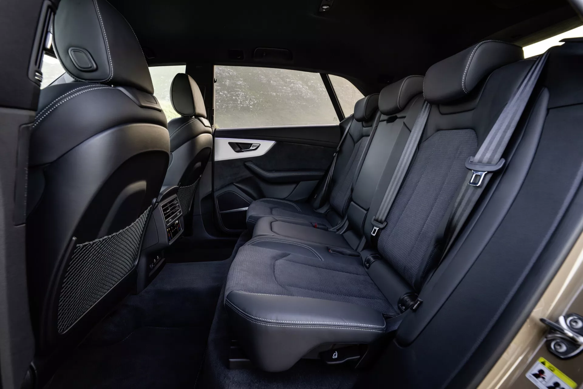 2023 Audi Q8 4M-Facelift interiör som visar bakre passagerarutrymmet från förarens sida med premium svarta lädersäten, detaljerad sömnad, lyxbekvämlighet och säkerhetsfunktioner