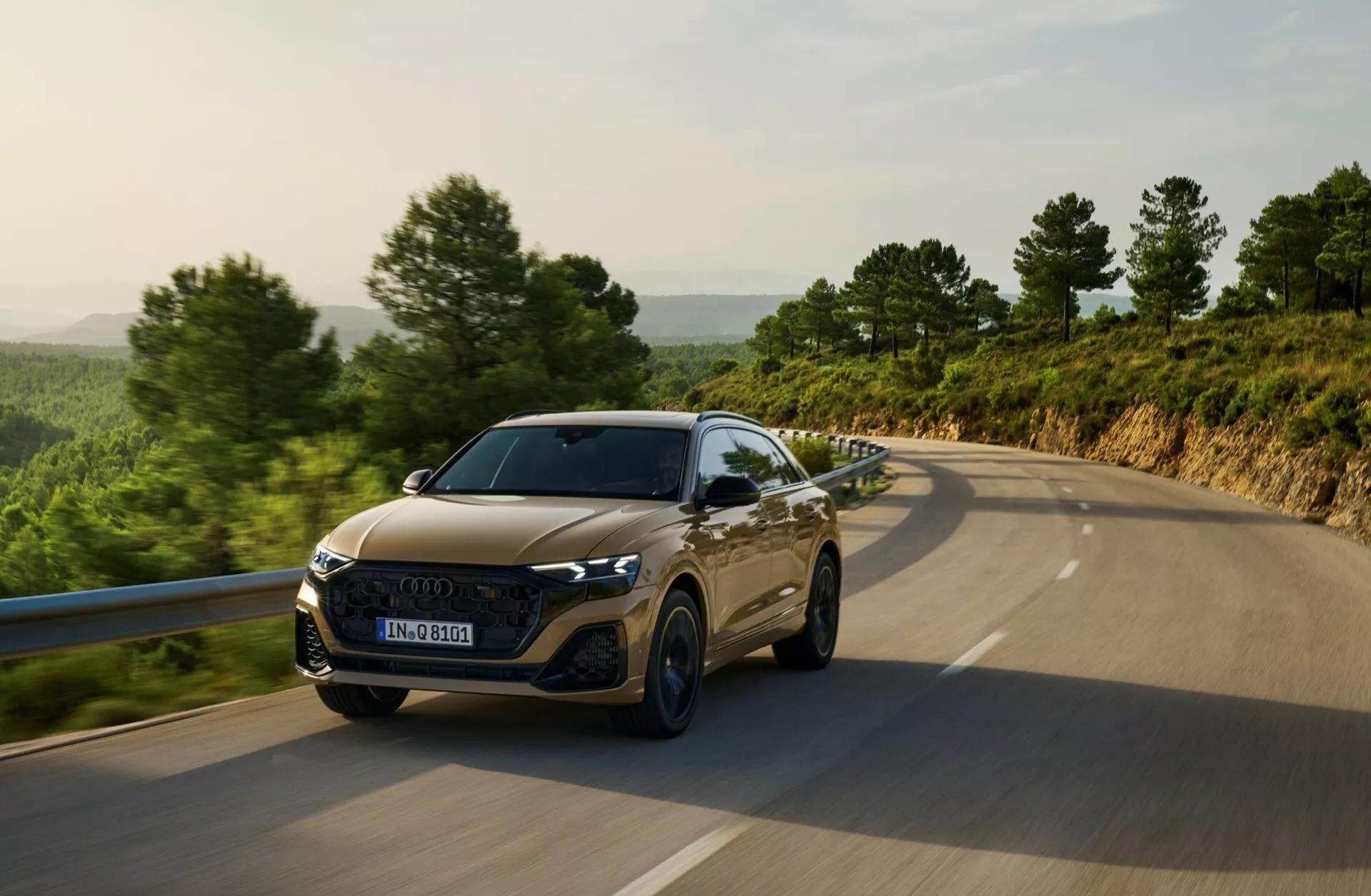 Audi Q8 4M Facelift 2023 som färdas på en landsväg, visar LED-strålkastare, hexagonal grill, sportiga motorhuvkonturer och avancerad förarassistans teknologi