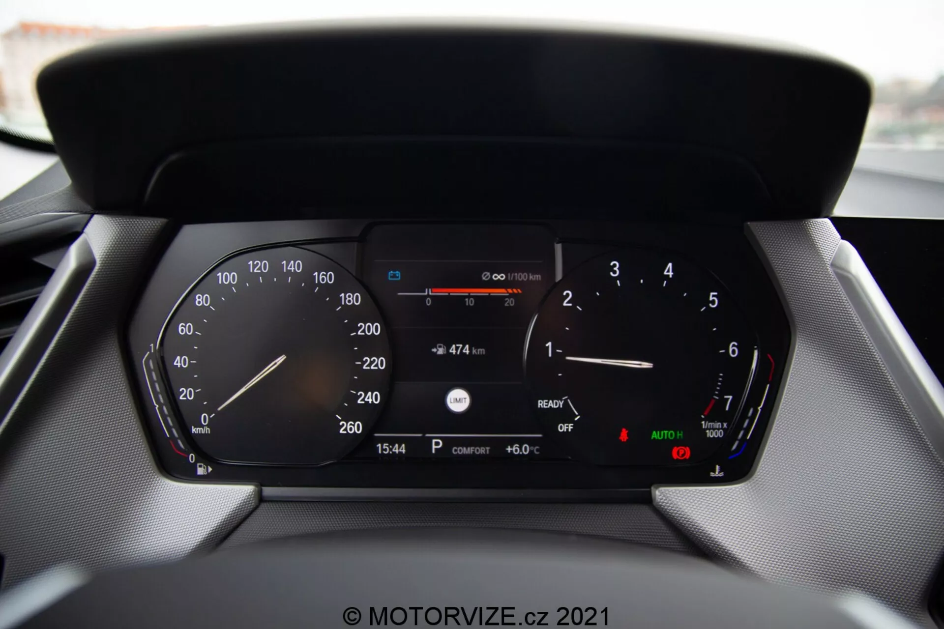 Närbild av en modern bils digitala instrumentpanel från en BMW 1-serie 2019 (BMW 116i), som visar detaljerade avläsningar inklusive hastighetsmätare, varvräknare, bränslemätare, temperaturmätare, digital hastighetsavläsning, återstående körsträcka med aktuell bränslemängd, tidsvisning (15:54), utomhustemperatur (6.0°C) och indikatorer för automatiska strålkastare och parkeringsbroms.