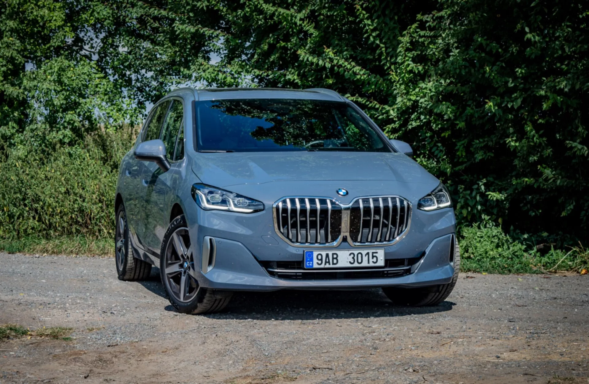 BMW 2-serien Active Tourer från 2022 parkerad på grus som visar upp sin sportiga design och moderna funktioner från en framifrån tre fjärdedels vinkel med naturlig bakgrund