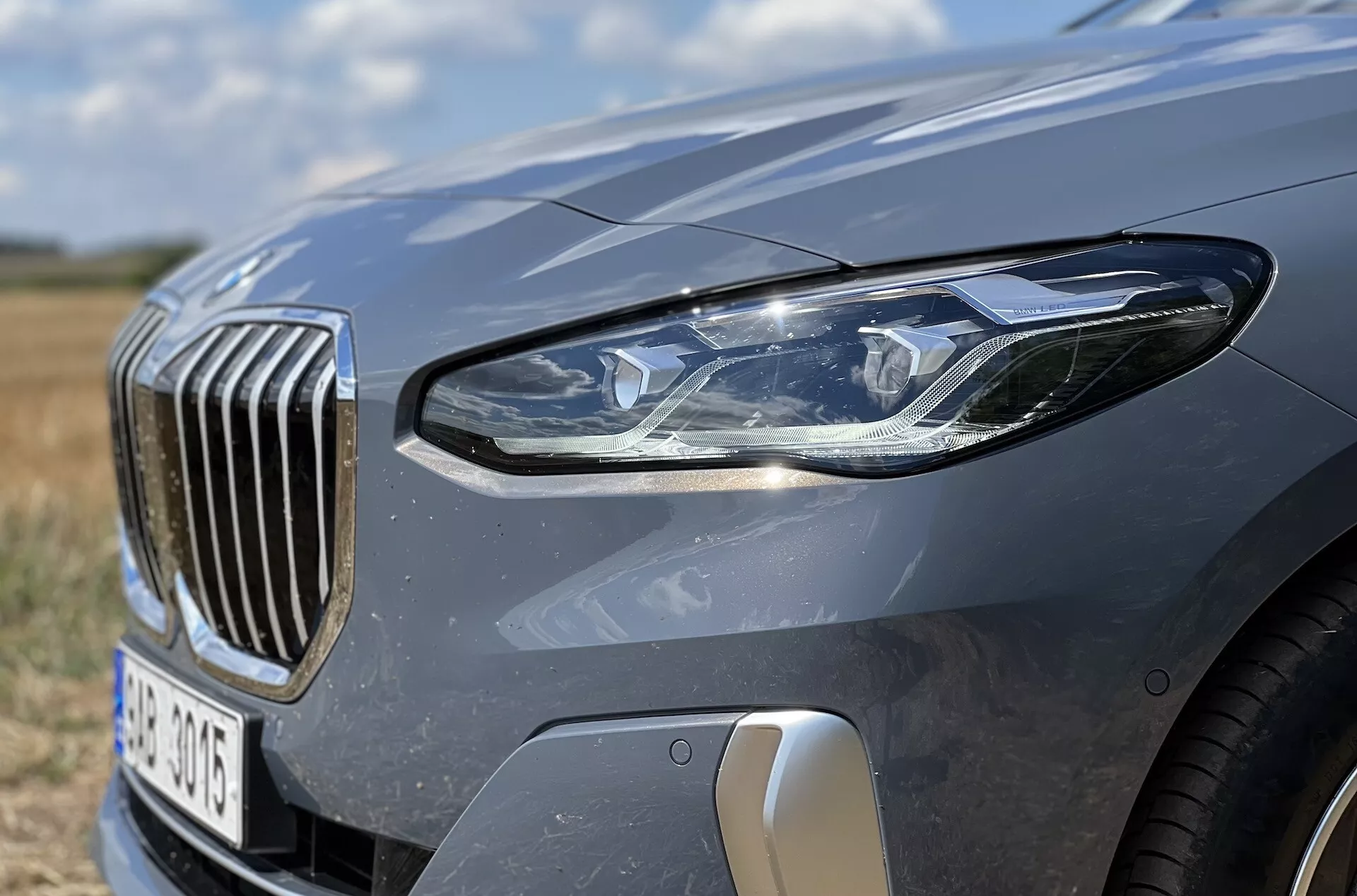 Närbild på främre vänstra kvartalet av BMW 2-serie Active Tourer 2022 som framhäver LED-strålkastarsamlingen, vertikalstång grill och aerodynamiska funktioner
