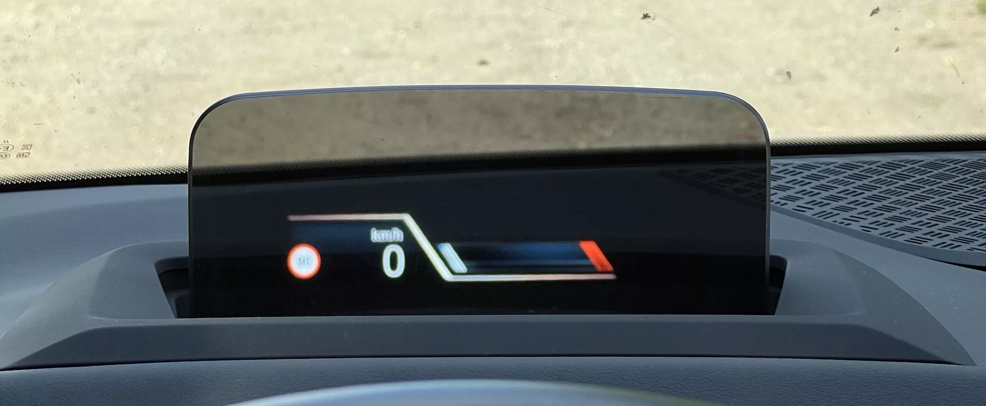 Närbild av huvuduppvisning i BMW 2-serien Active Gran Tourer 2022 som visar hastighet och bränslenivå, framhäver avancerad säkerhets- och informationsteknologi