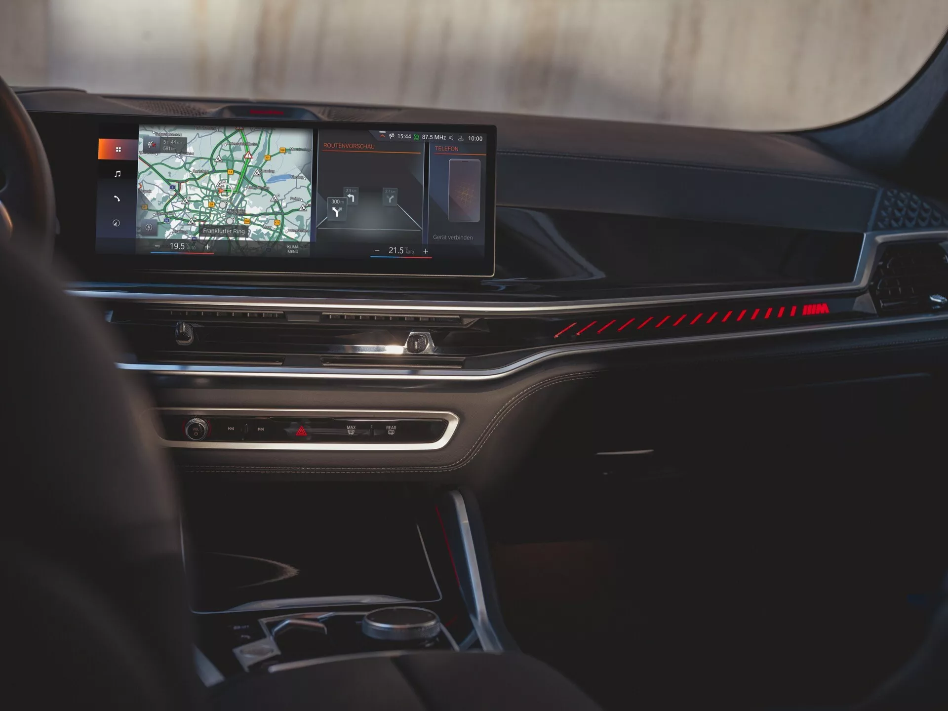 Interiörvy av BMW X6 2023 (G06-F96-facelift) med fokus på instrumentbrädan, stor infotainmentskärm som visar navigation, och snygg klimatkontrollpanel, från bakre passagerarens perspektiv