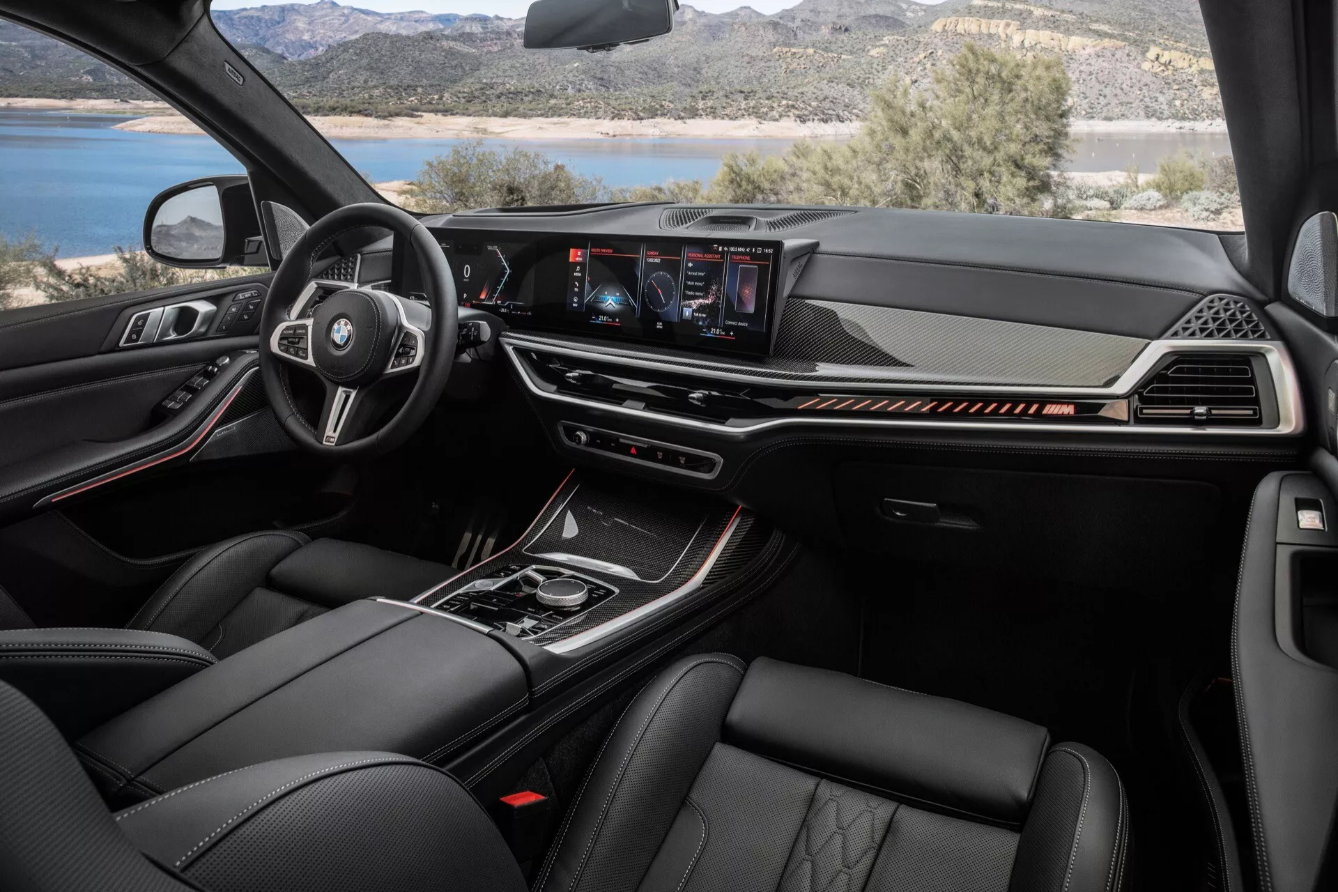 Interiör av BMW X7 (G07-facelift) 2022 som visar multifunktionella läderratten med tillverkarens logotyp, digital instrumentpanel, central touchscreen-infotainmentsystem och premiummaterial inklusive lädersäten med avancerade klimatkontrollfunktioner från framsätespassagerarens perspektiv