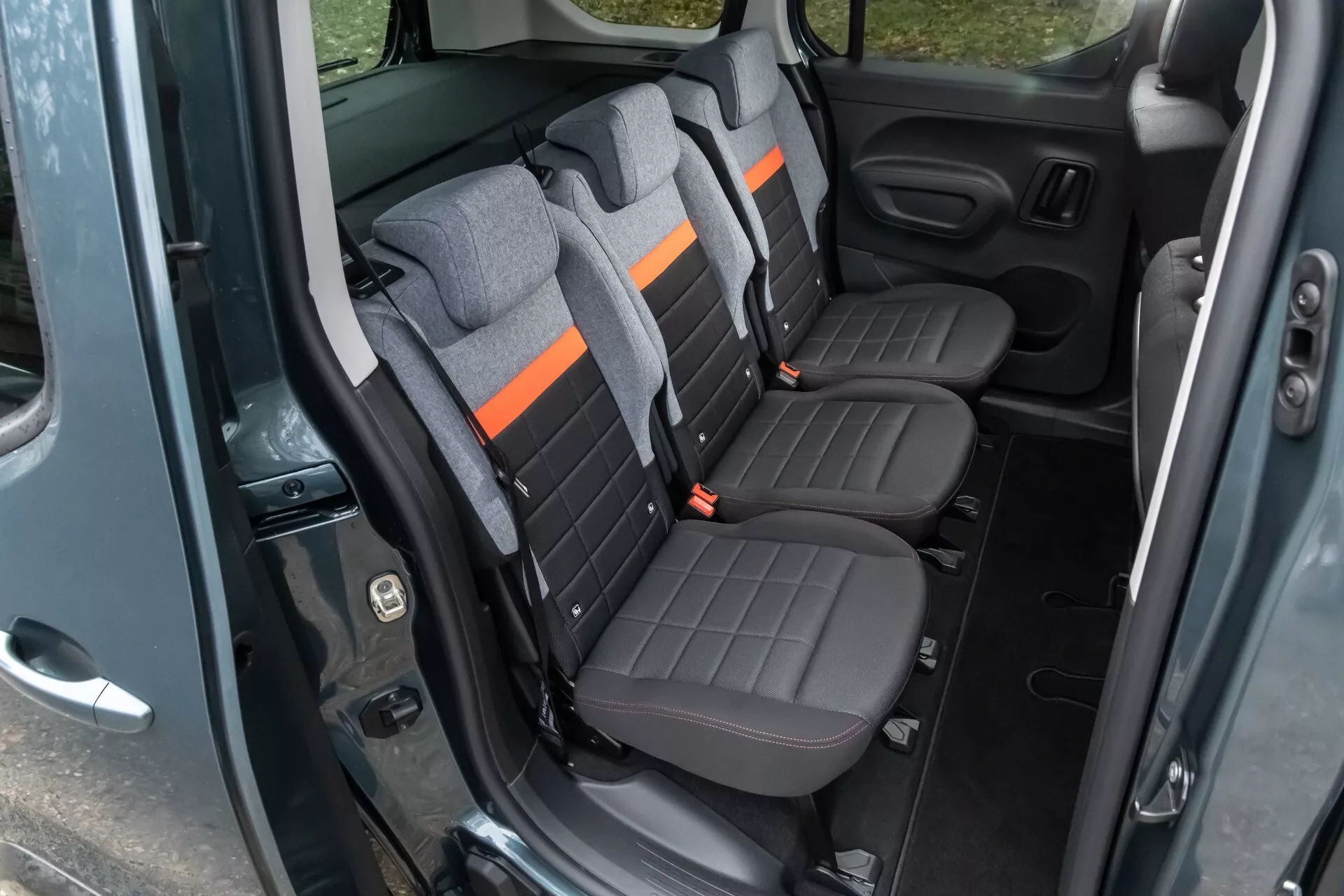 Interiör av Citroen Berlingo 2024 visar bakre passagerarområdet med tvåtoniga säten och avancerade funktioner från en diagonal vy
