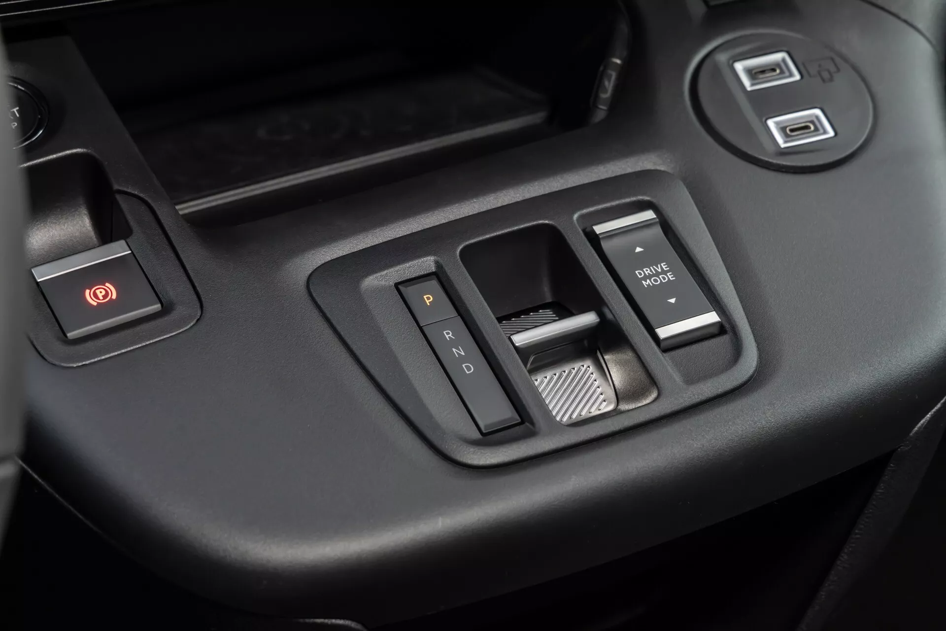 Närbild av 2024 Citroen Berlingo tredje generationens facelift interiör med fokus på förarsidans dörrkontrollpanel med varningslampa för fara, fönsterkontroller och spegeljusteringsknappar