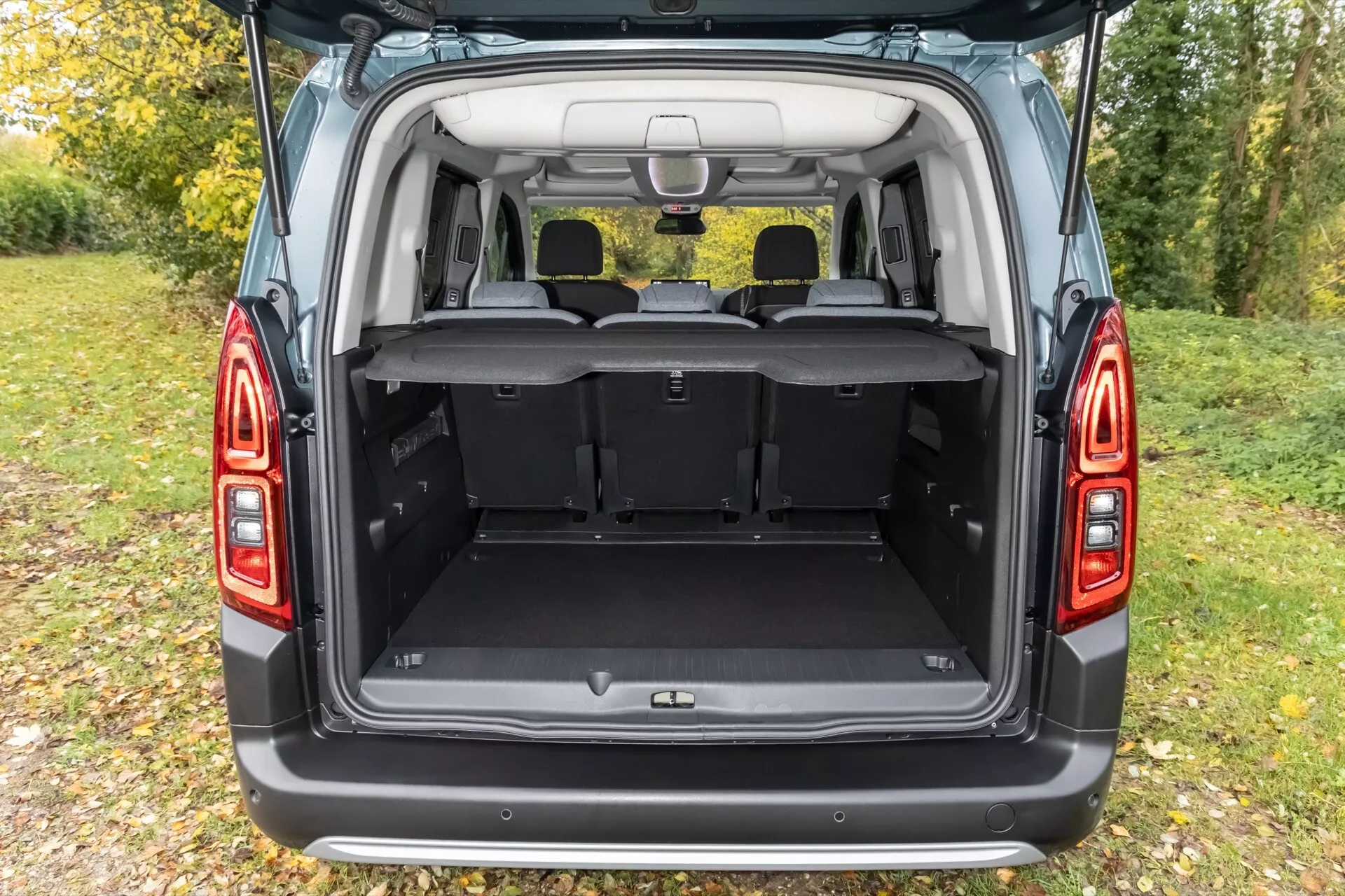 Bakifrån vy av Citroen Berlingo 2024 (3:e generationen - Facelift) med bakluckan öppen som visar det rymliga lastutrymmet och den moderna designen på bakljusen, vilket framhäver SUV/minivans förvaringskapacitet, användbarhet och LED-belysningsteknik