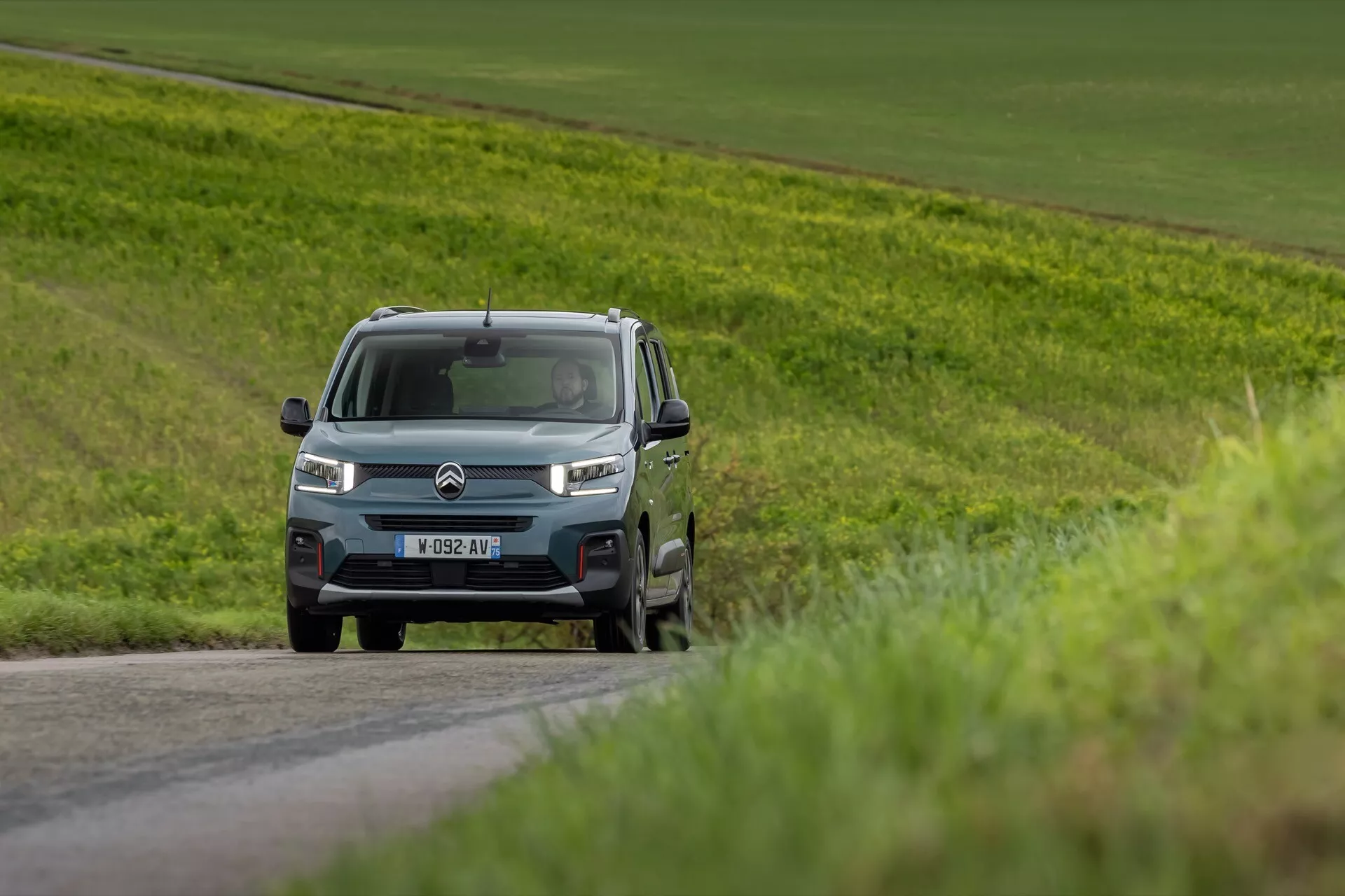 Facelift modell av Citroen Berlingo 2024 körande på landsväg, visar frontgrill, LED strålkastare och sidoprofil