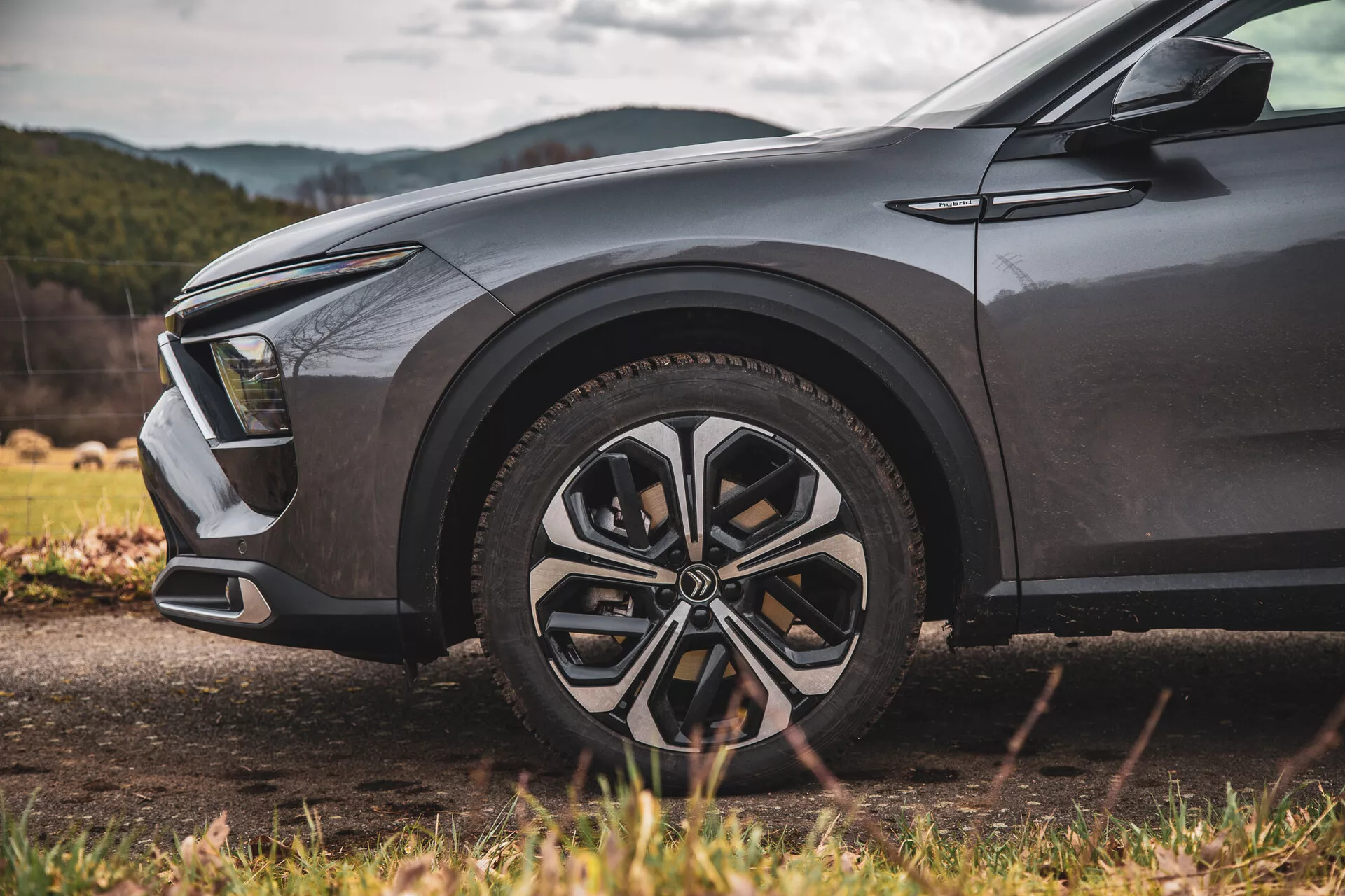 Frontkvartersvy av en Citroen C5-X 2022 med fokus på legeringshjulet och moderna LED-strålkastare från en låg vinkel