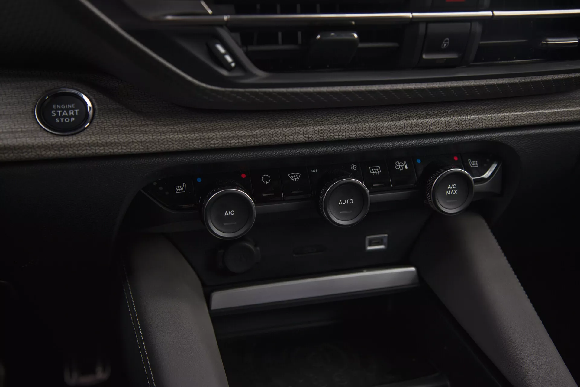 Närbild av interiören i Citroen C5-X 2022 med knapp för start/stopp av motor utan nyckel och avancerat klimatkontrollsystem med AUTOMATISK temperaturreglering och alternativ för luftåtercirkulation.