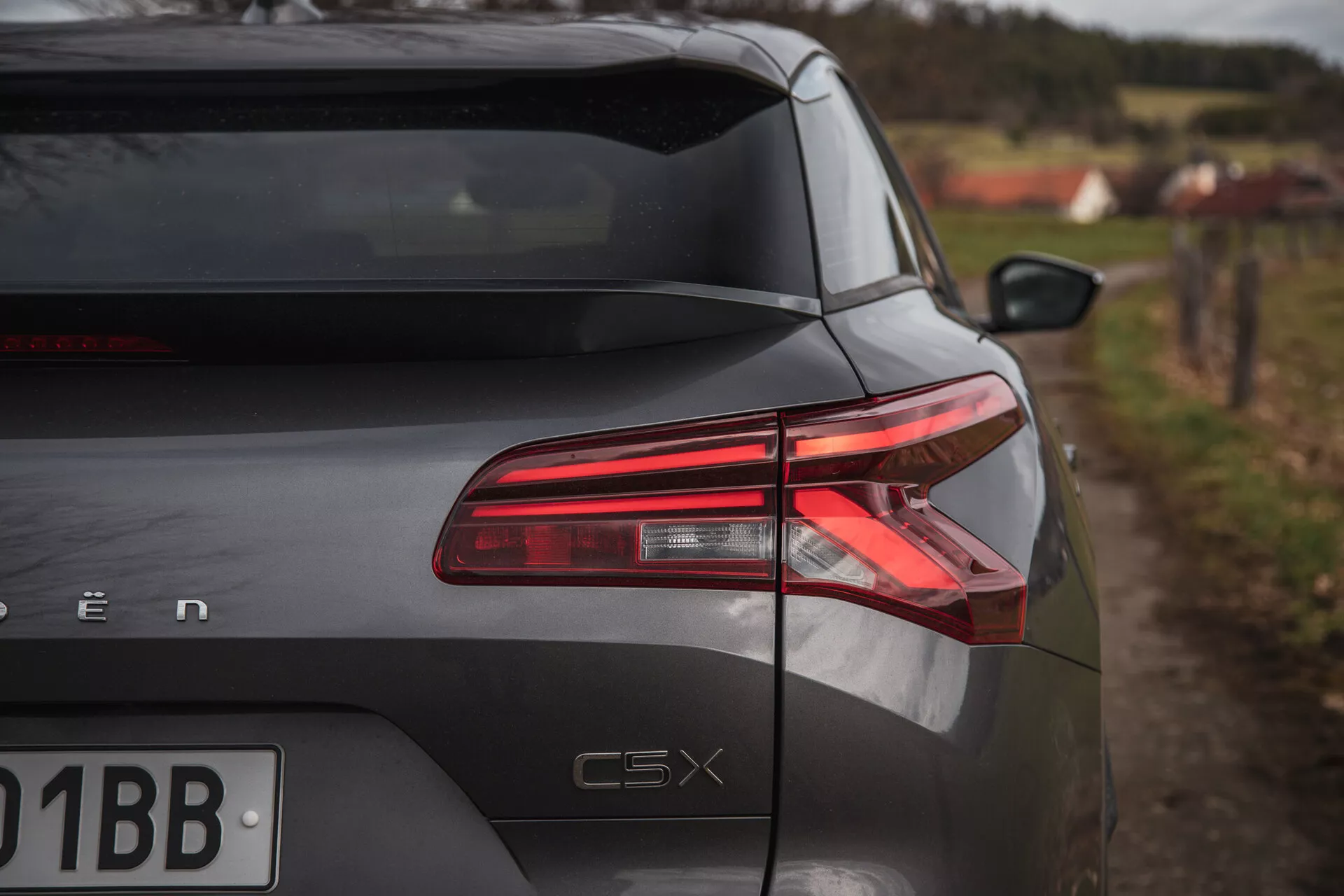 Baksidan av Citroen C5-X 2022 från en sned vinkel som visar LED-bakljus, glansig finish och modellmärkning