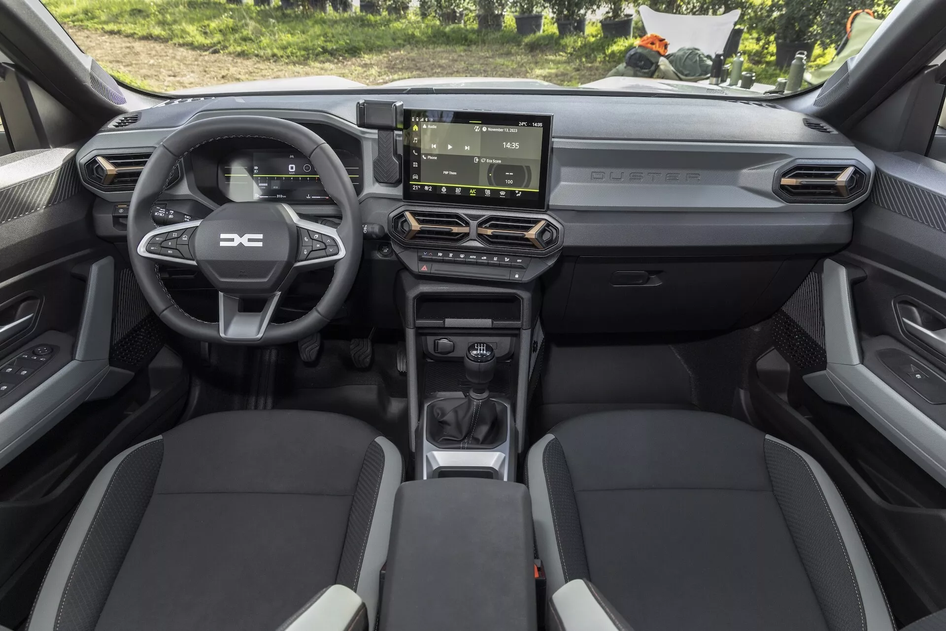 Interiörvy av Dacia Duster 3:e generationen 2024 från en hög främre vinkel som visar modern automatväxellåda, ergonomisk mittkonsol, pekskärmsunderhållningssystem och minimalistisk instrumentpanel design med högkvalitativa ytbehandlingar.