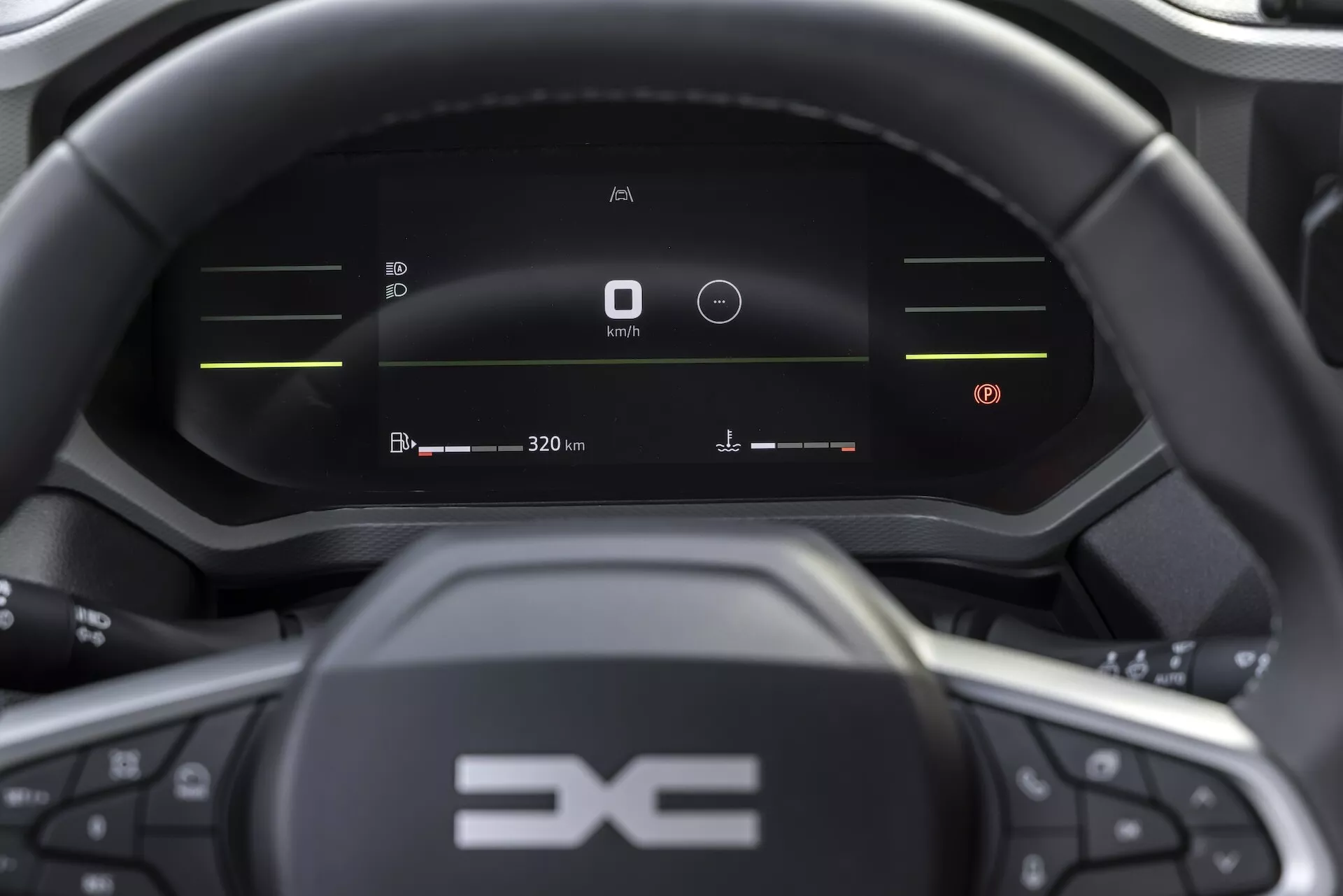 Interiören i Dacia Duster 2024 som visar en digital instrumentpanel med varvräknare, batteriladdningsindikator och digital hastighetsmätare som visar 0 km/h, vilket lyfter fram tekniken för el- eller hybridfordon