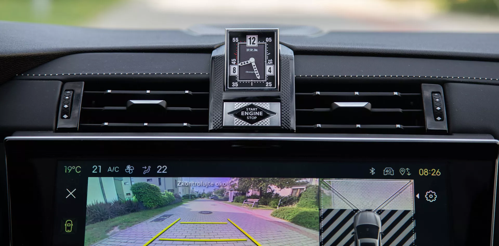 Interiörvy av DS Automobiles DS-7 2022 som visar instrumentbrädan, lyxig analog klocka och det centrala infotainmentsystemets display med backkamera och parkeringsassistansfunktion