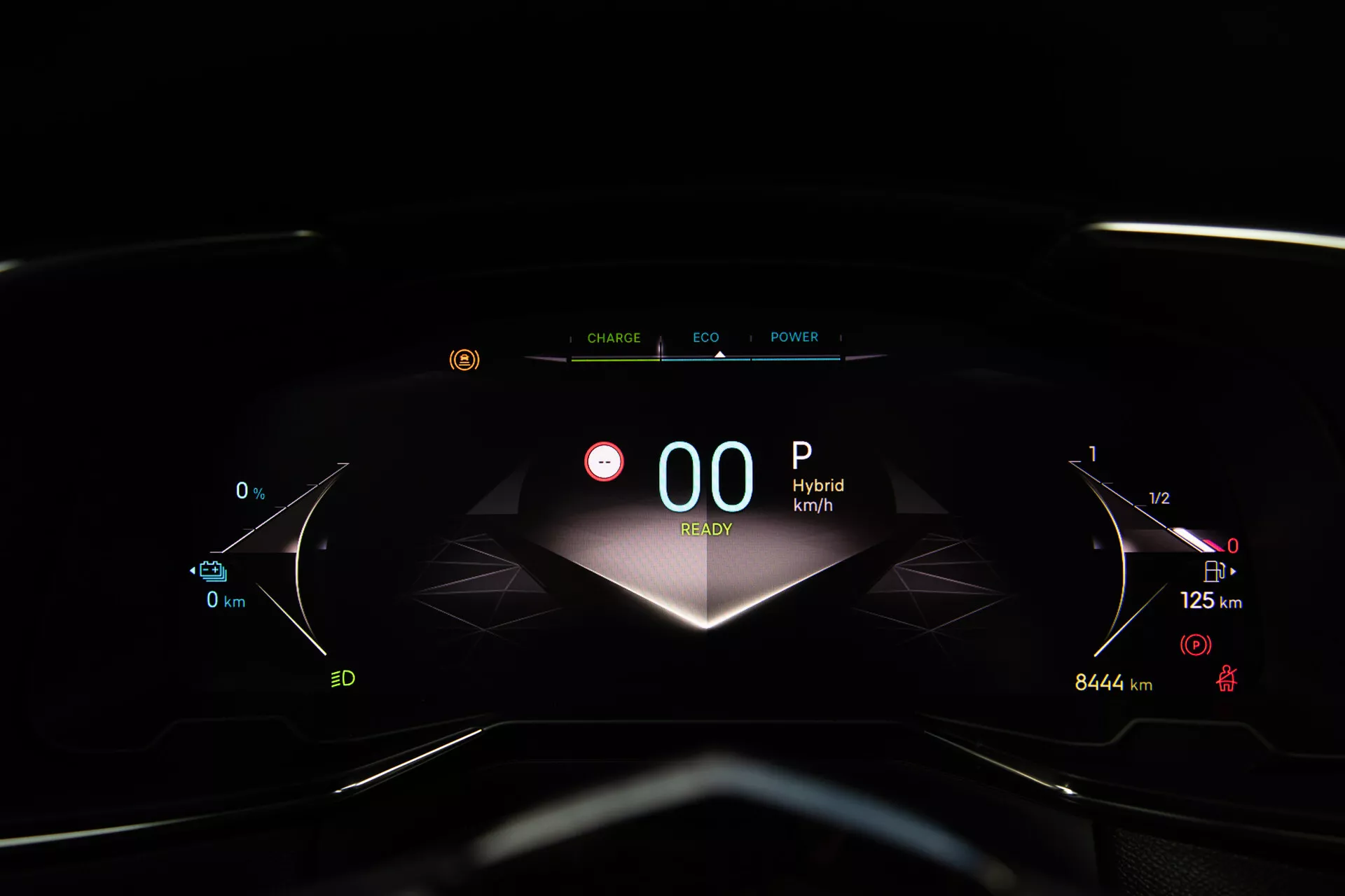 Närbild av instrumentpanelen på DS Automobiles DS-7 2022 som visar digitalt instrumentkluster med 'Hybrid'-indikering, stillastående hastighetsmätare på '00' km/h, full tankmätare och energihanteringsikoner från förarens sätesperspektiv