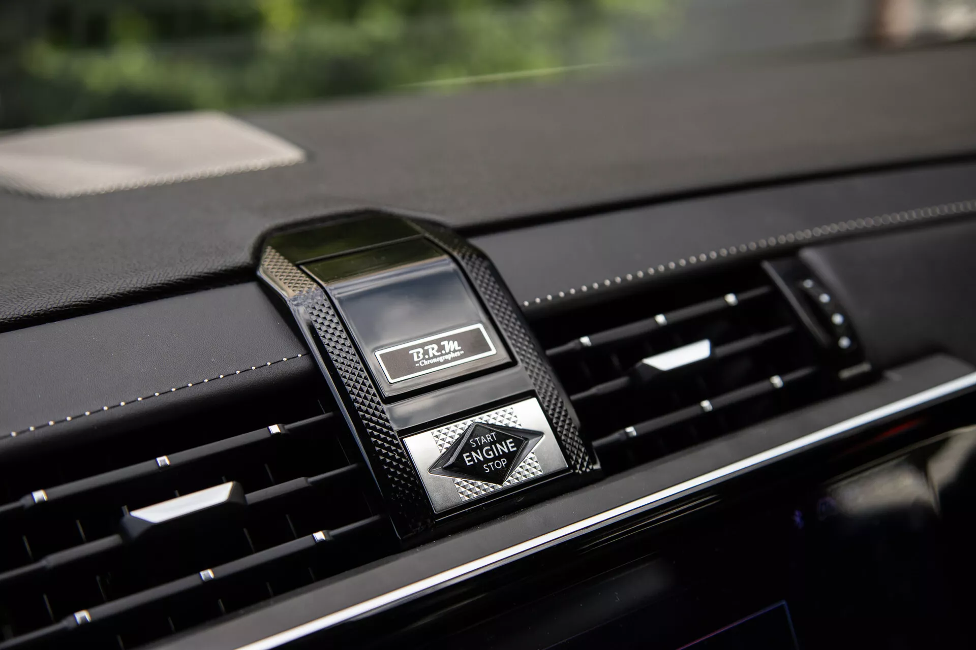 Närbild av mittkonsolen i DS Automobiles DS-7 2022 med lyxig analog klocka och luftventiler, vilket framhäver premiummaterial och modern design