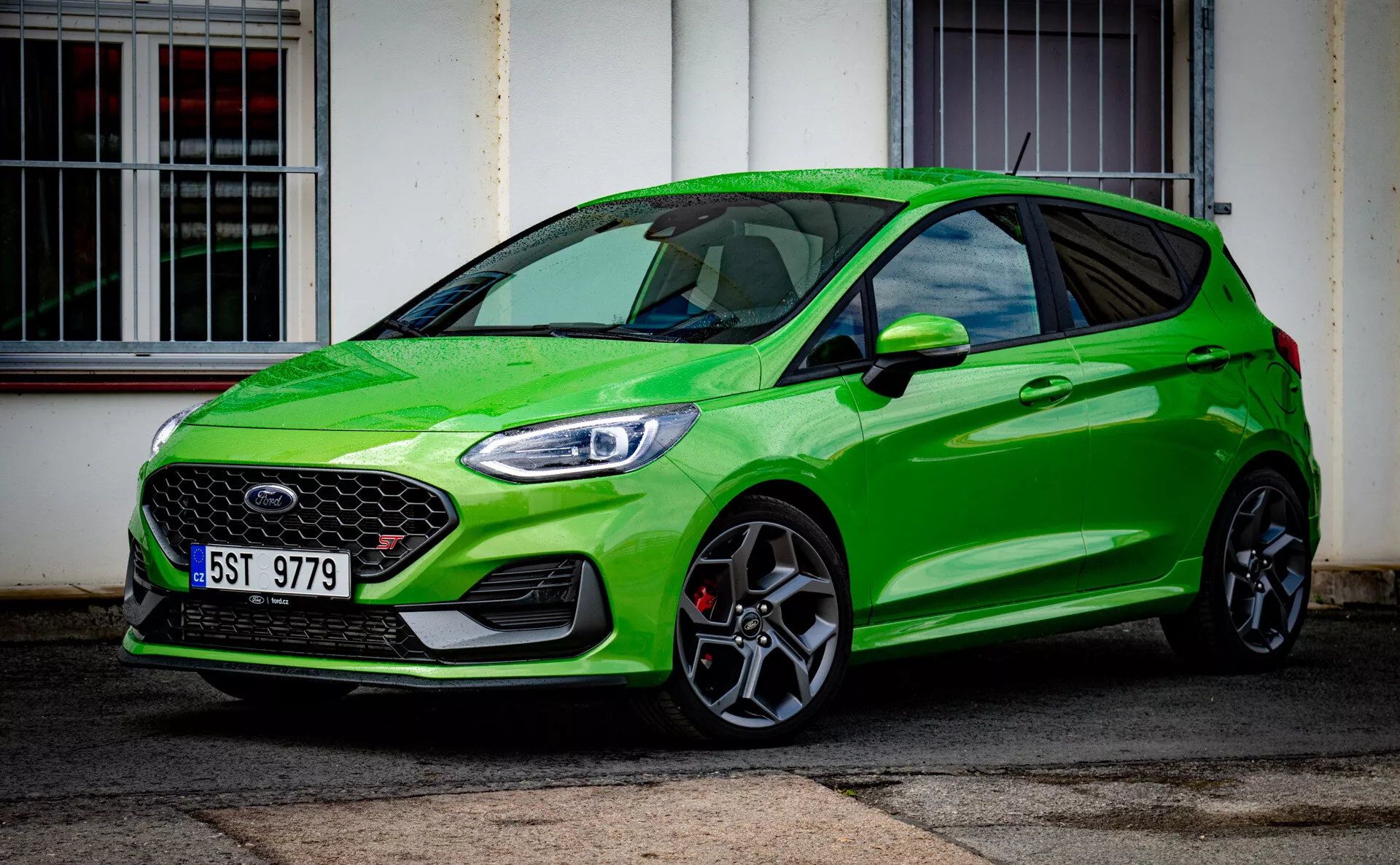2022 lysgrön Ford Fiesta modern hatchbackmodell betonar sportig statur med framträdande frontgrill och snygga LED-strålkastare, parkerad diagonalt framför en byggnad