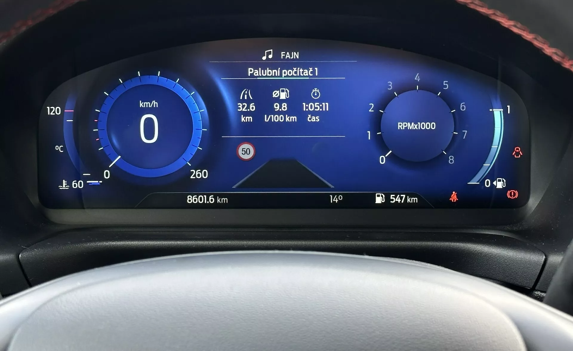 Digital instrumentbräda för Ford Fiesta 2022 som visar närbild på framsidan med hastighetsmätare, varvräknare, bränsleeffektivitetsmätare och olika fordonstillståndsindikatorer i en modern design med blått och vitt färgschema.