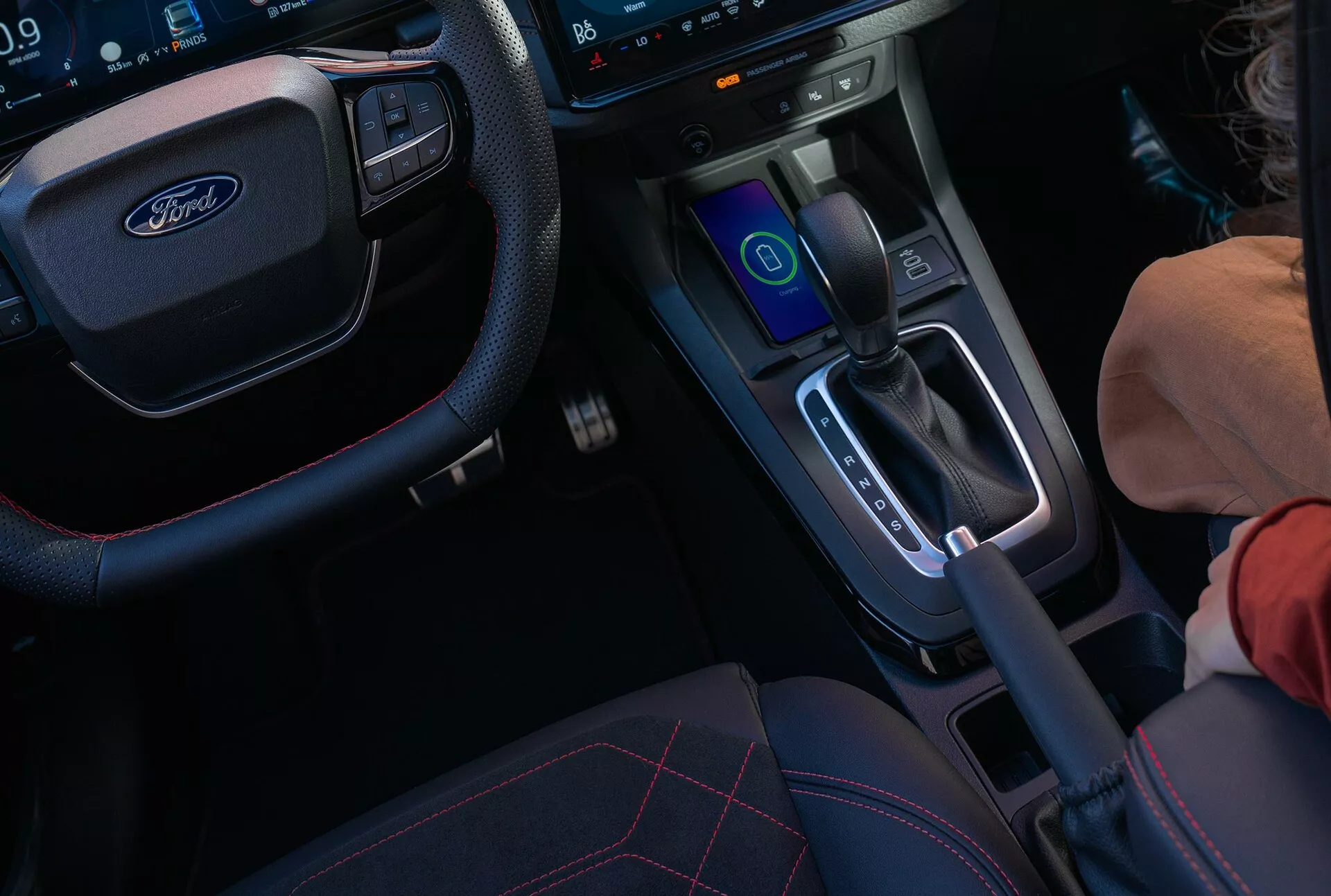 Interiörvy av Ford Puma II facelift 2024 med fokus på mittkonsolen och ratten med digital instrumentbräda och pekskärmsinfotainmentsystem