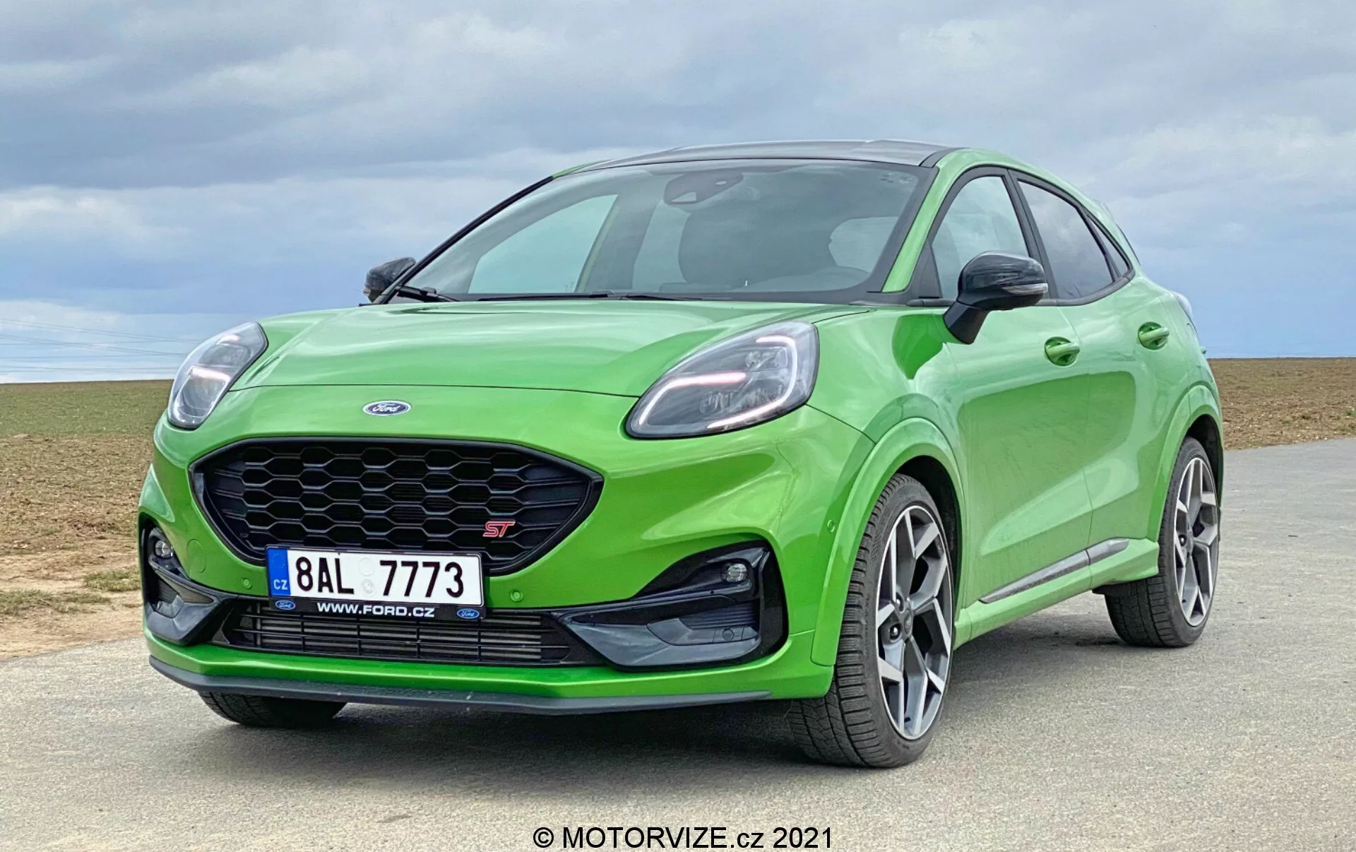 2020 Ford Puma ST ljusgrön modern halvkombi med framträdande bikakegrill, eleganta vinklade strålkastare, stötfångare i karossens färg och prestandainriktade flerspoked lättmetallfälgar fotograferad från låg vinkel i ett trekvartsperspektiv som visar dess dynamiska stance, aerodynamiska profil och sportiga design i en utomhusmiljö.