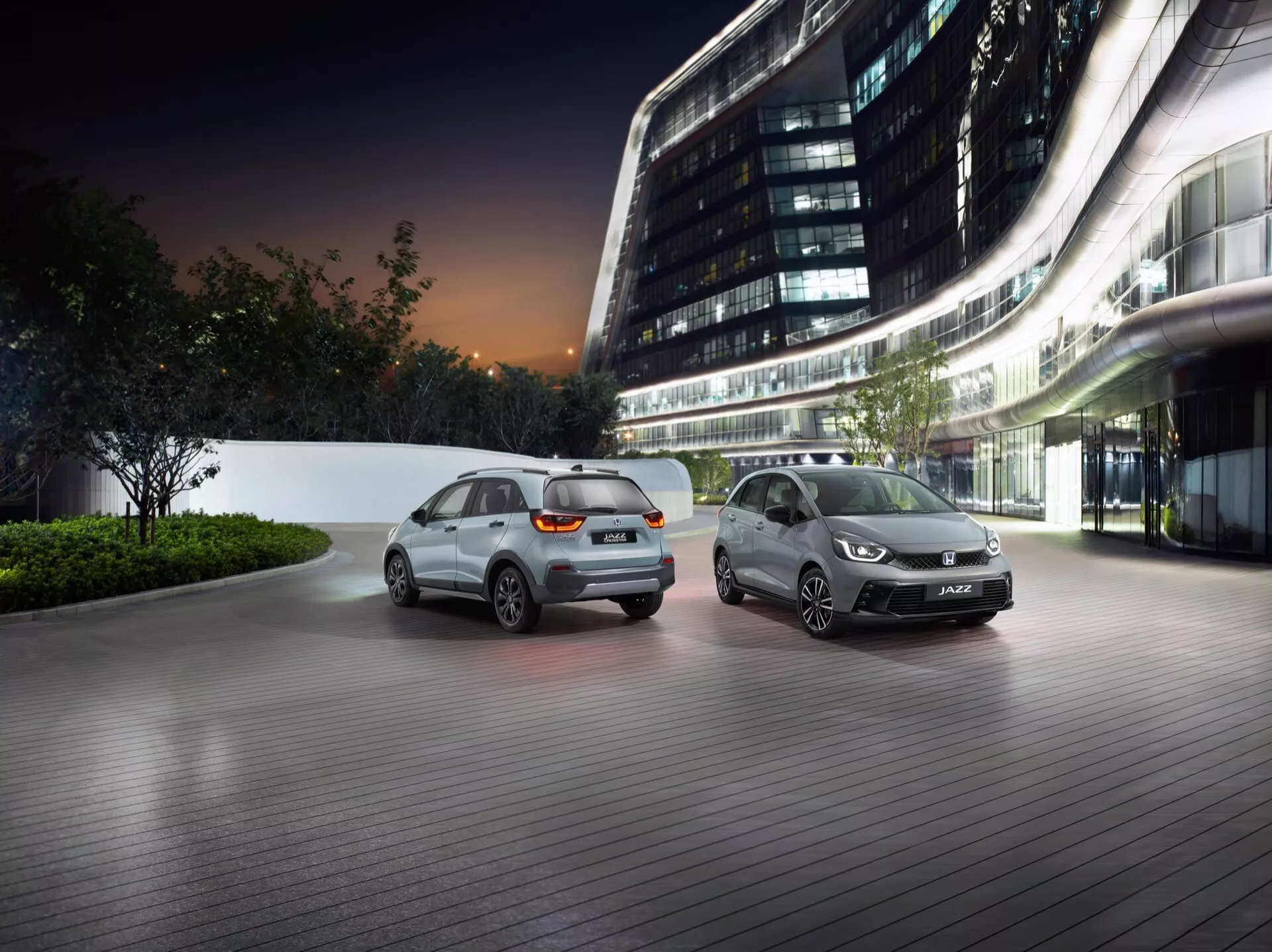Honda Jazz 5: e generationens facelift 2023 visas i en lyxig stadsinställning vid skymningen, som visar avancerade designfunktioner och belysningsteknologi