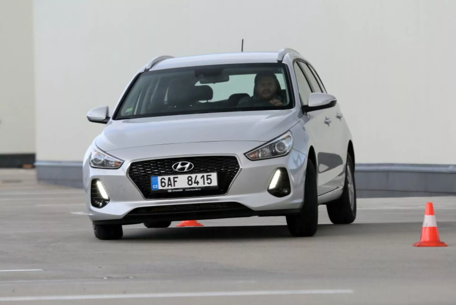 Hyundai i30 N från 2017 i rörelse, visar dess frontgrill med hexagonalt mönster och kromkontur, LED-strålkastare och aerodynamisk design med aluminiumfälgar, fångad på en körbana