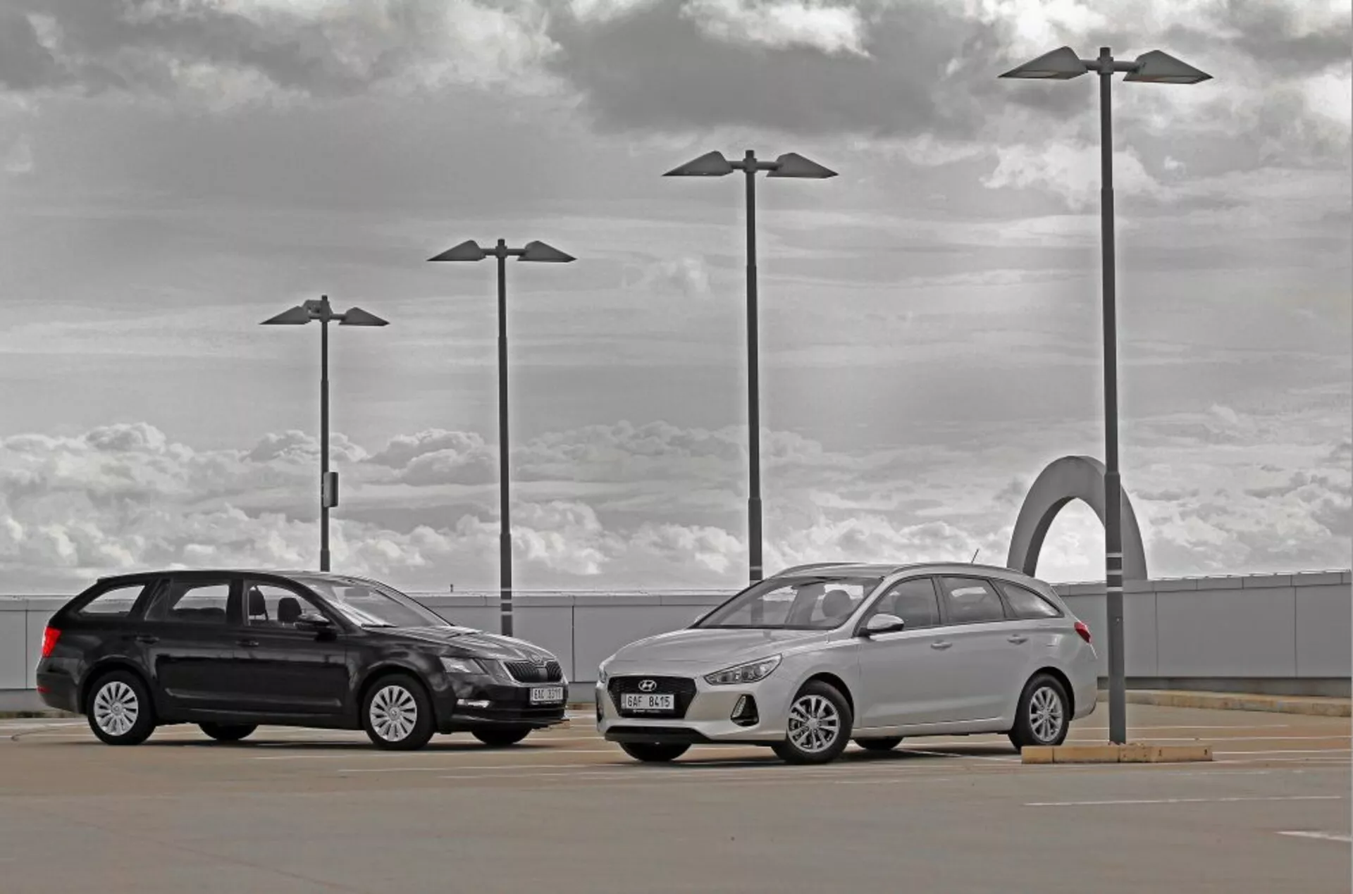 Hyundai i30 2017 kombi och sedan på en utomhusparkering under en molnig himmel med urbana designelement