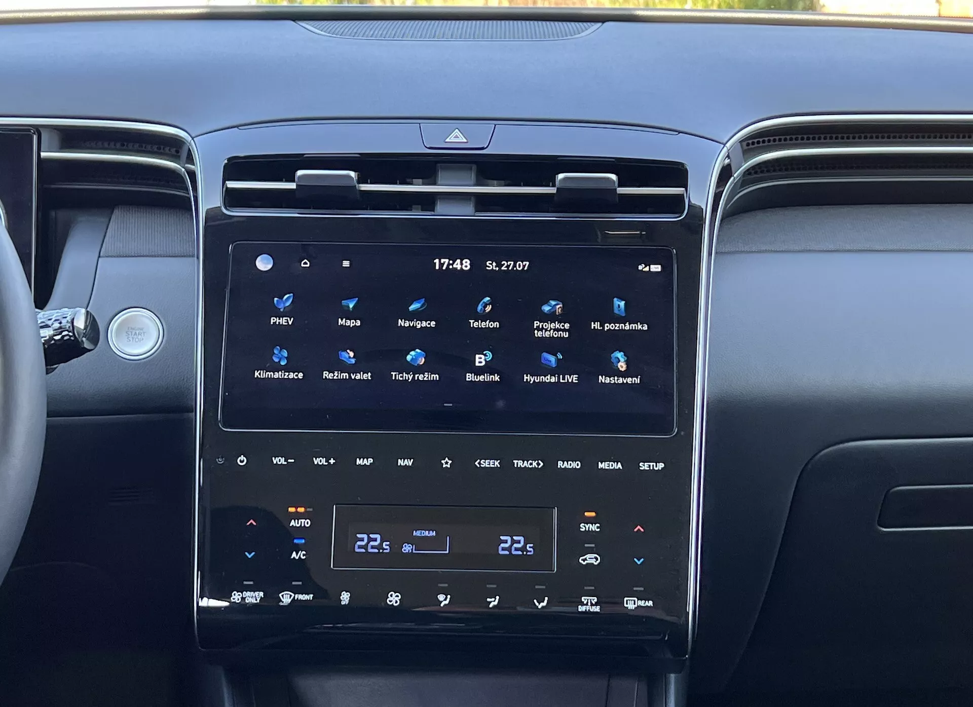 Interiören i Hyundai Tucson 2020 som visar mittkonsolen med en stor, vertikal pekskärm för infotainmentsystemet, tvåzons klimatkontroll och omgivande luftventiler, som reflekterar modern fordons teknologi och lyx