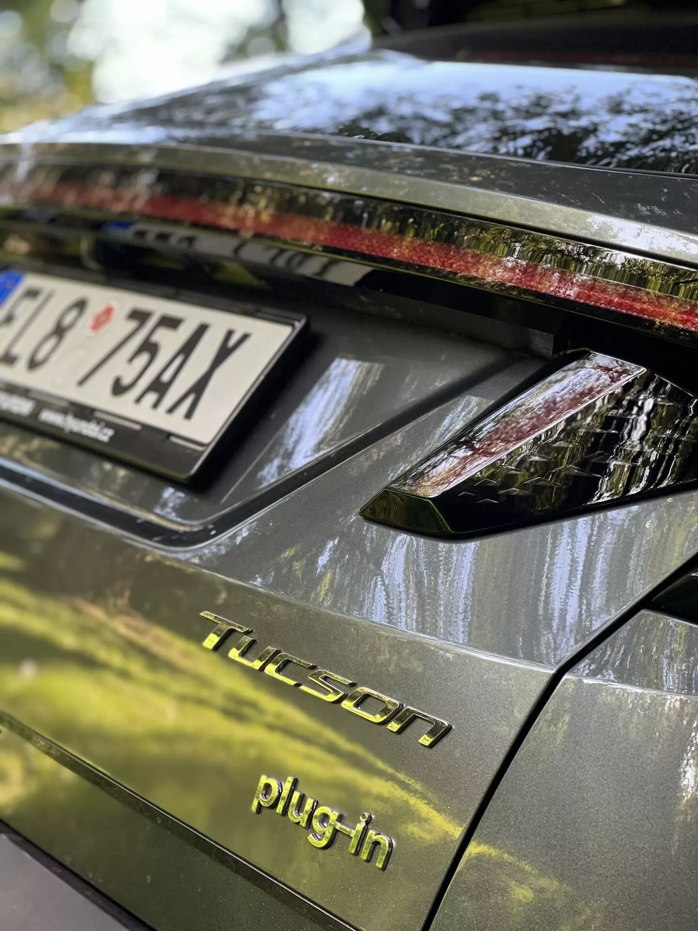 Närbild av bakdelen på en Hyundai Tucson 2020 plug-in hybrid, med bagagelucka, bakre ljusarrangemang med LED-lampor, mörkt glansigt slut, och detaljer som indikerar parkering utomhus