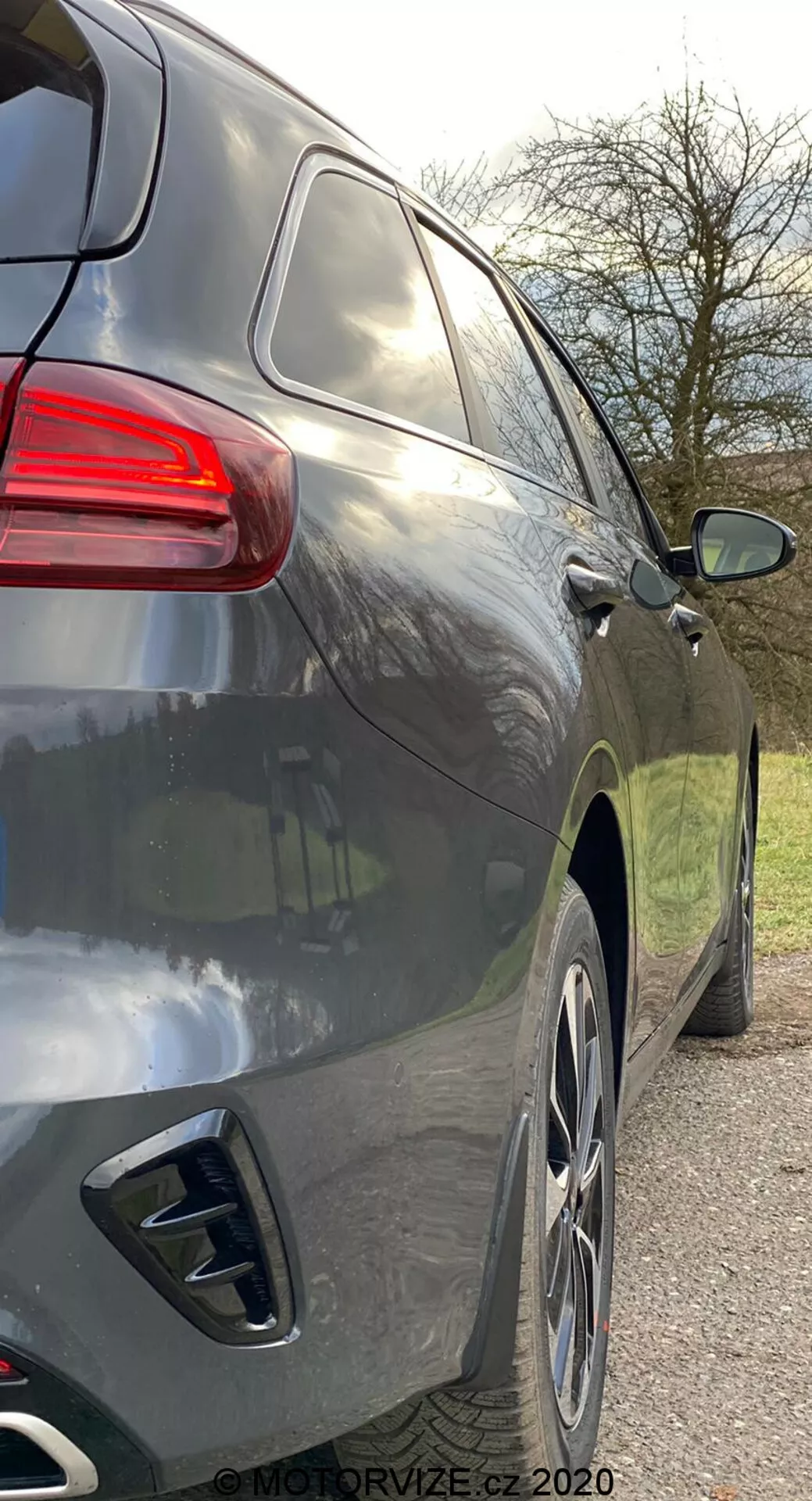 Närbild på den högra sidovyn av en modern SUV från en något bakåtvänd vinkel som visar den bakre delen och sidoprofilen från den bakre dörrhandtaget till bakljusen, med släta aerodynamiska linjer, mörk metallisk lack, stora lättmetallfälgar, dubbla avgasrör, tonade rutor och ett bakljus med modern design.