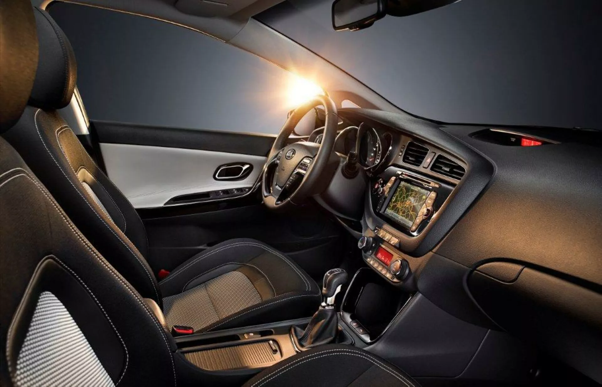Interiör av Kia Cee'd 2009 som framhäver förarsidan med ratten till vänster, instrumentkluster, pekskärmsinfotainmentsystem, klimatkontroller, automatväxellåda och moderna designaccent, som betonar teknik, komfort och sportig aspekt