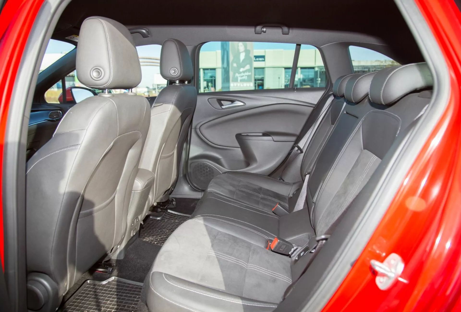 Närbild på interiören i en Kia Ceed från 2009 som visar baksätet sett från förarsidans bakdörr, framhäver klädsel i tvåfärgad tyg och ergonomisk sätesdesign för ökad komfort