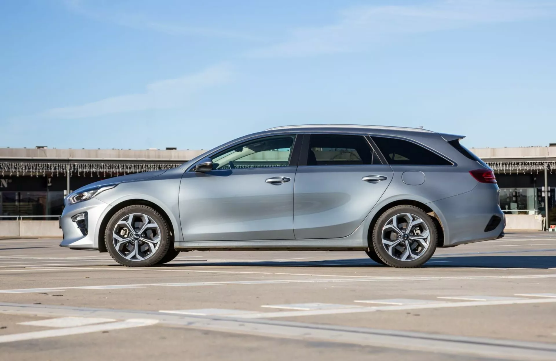 Stationvagn Kia Cee'd 2009 på parkeringsplats, visar sidoprofil, legeringshjul och designegenskaper under naturligt solljus