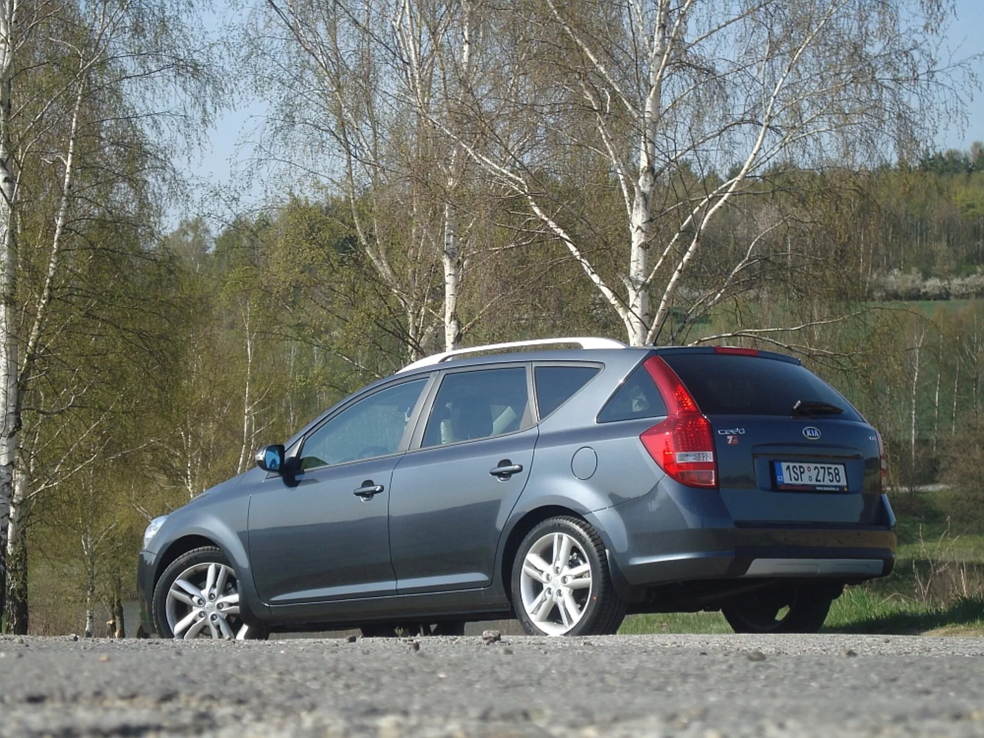 2009 Kia Ceed station vagn i grå, visar sida och bakre design, med fokus på aerodynamisk taklinje, baklyktor och bakfönster, parkerad utomhus