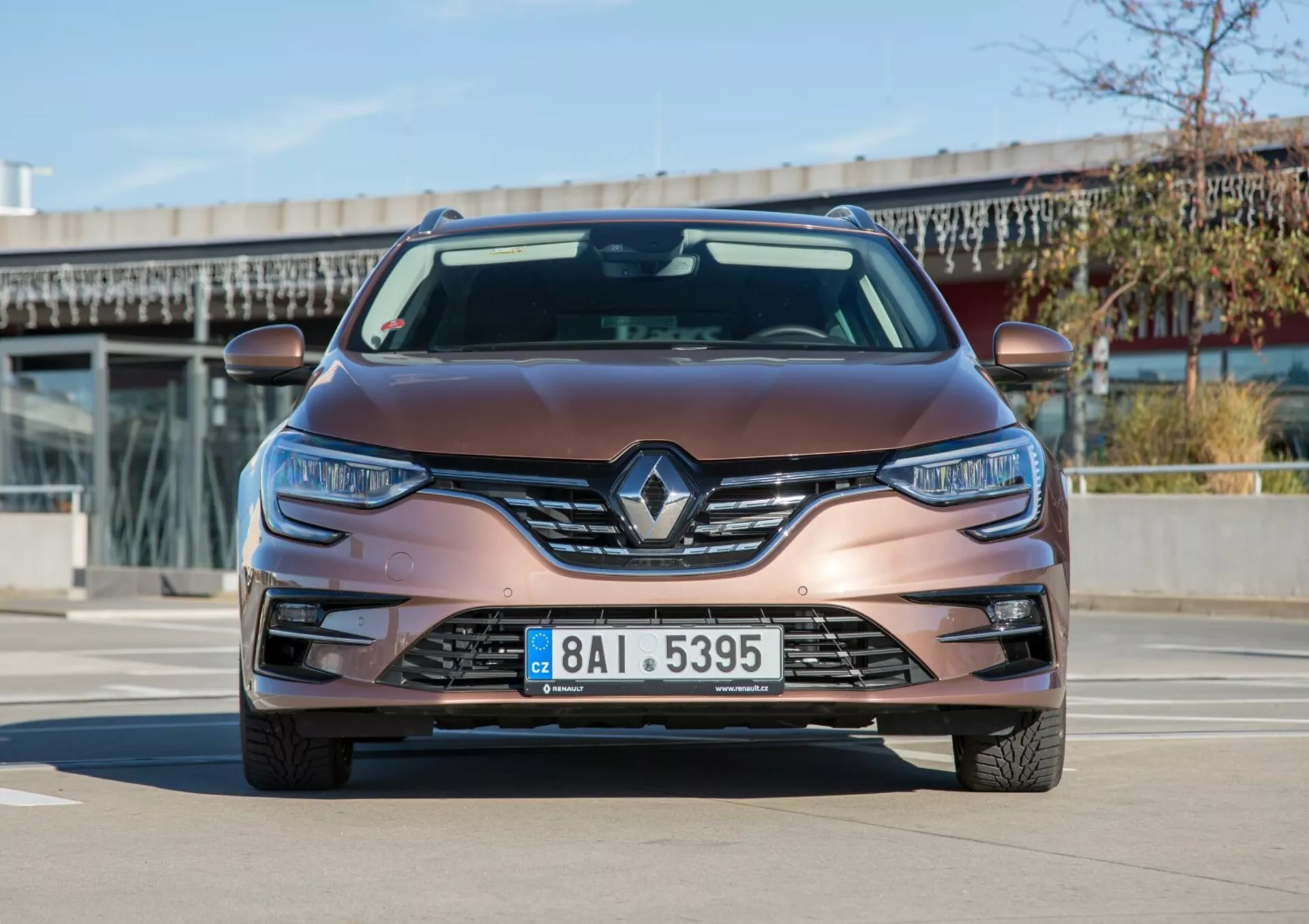 Främre vy av en Kia Cee'd från 2009 i metallisk brun, med Renault-logotyp, LED-strålkastare och dimljus, fotograferad i dagsljus, visar modern design och teknik.