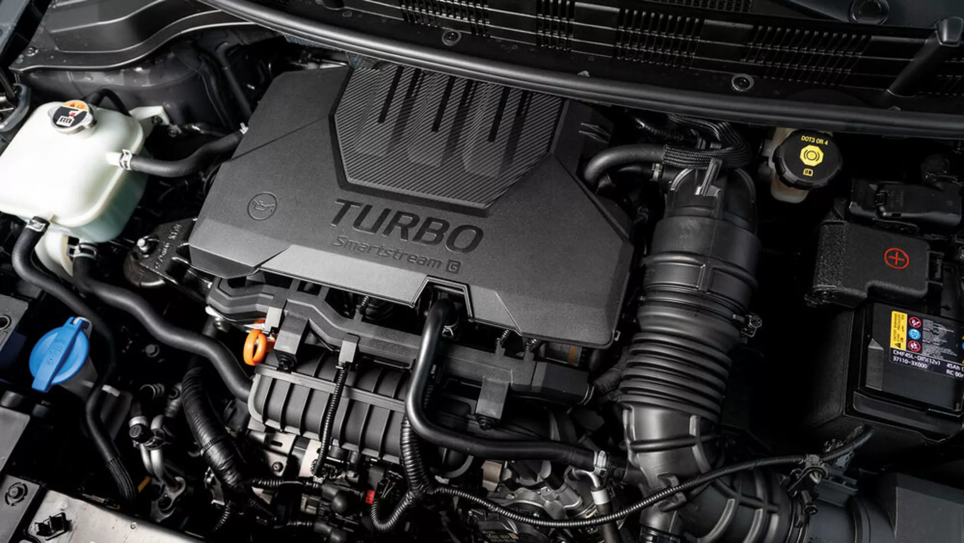 När vy av Kia Stonic 2017 motorrum med turbo laddad motorkåpa och olika mekaniska komponenter synliga, visar upp den tekniska aspekterna av fordonet
